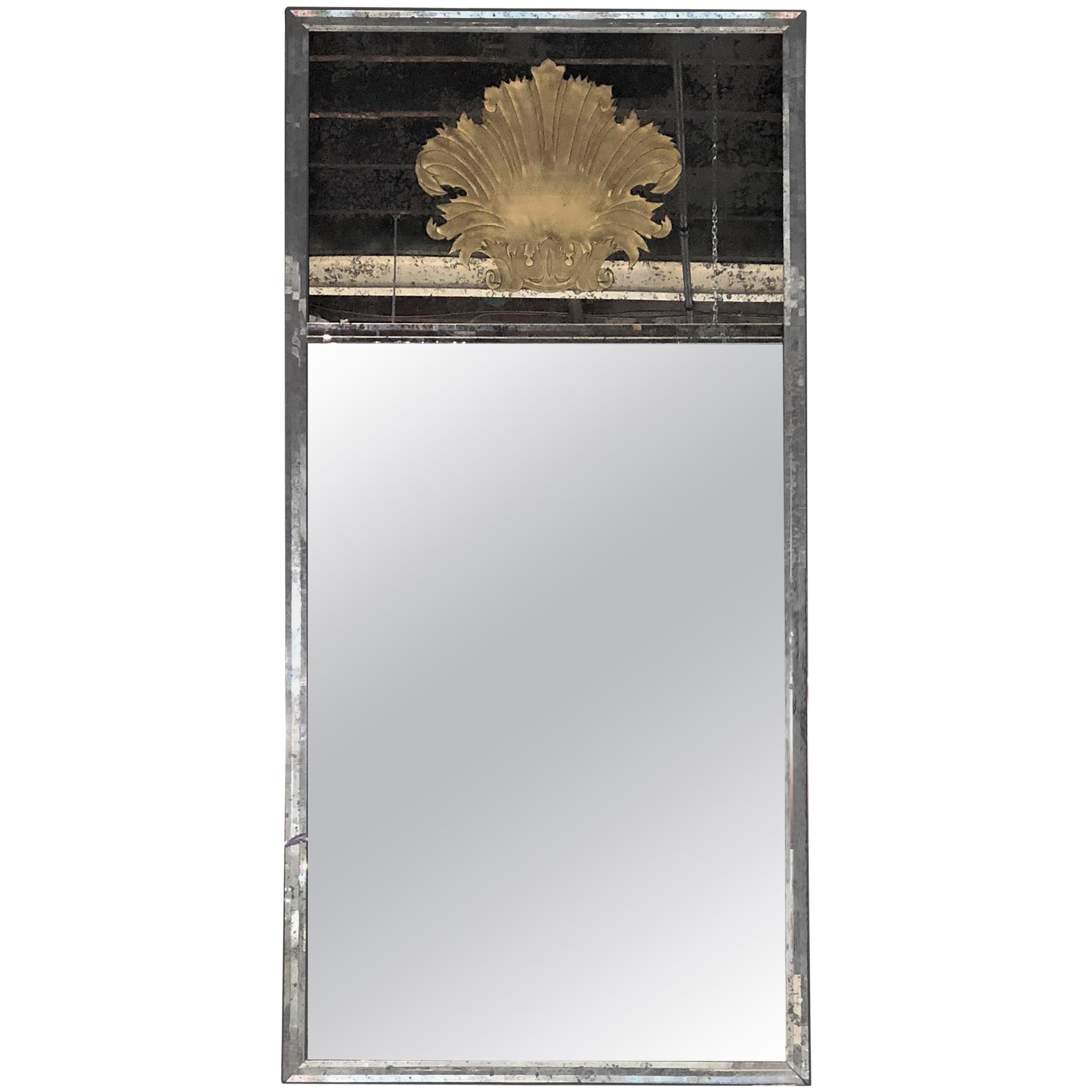 A stunning pair of etched glass metal framed custom gilt shell designed mirrors. Each of these palatial wall or console mirrors depicts the Hollywood Regency and Art Deco era at its most grandeur state. Set in a solid steel frame the center mirror