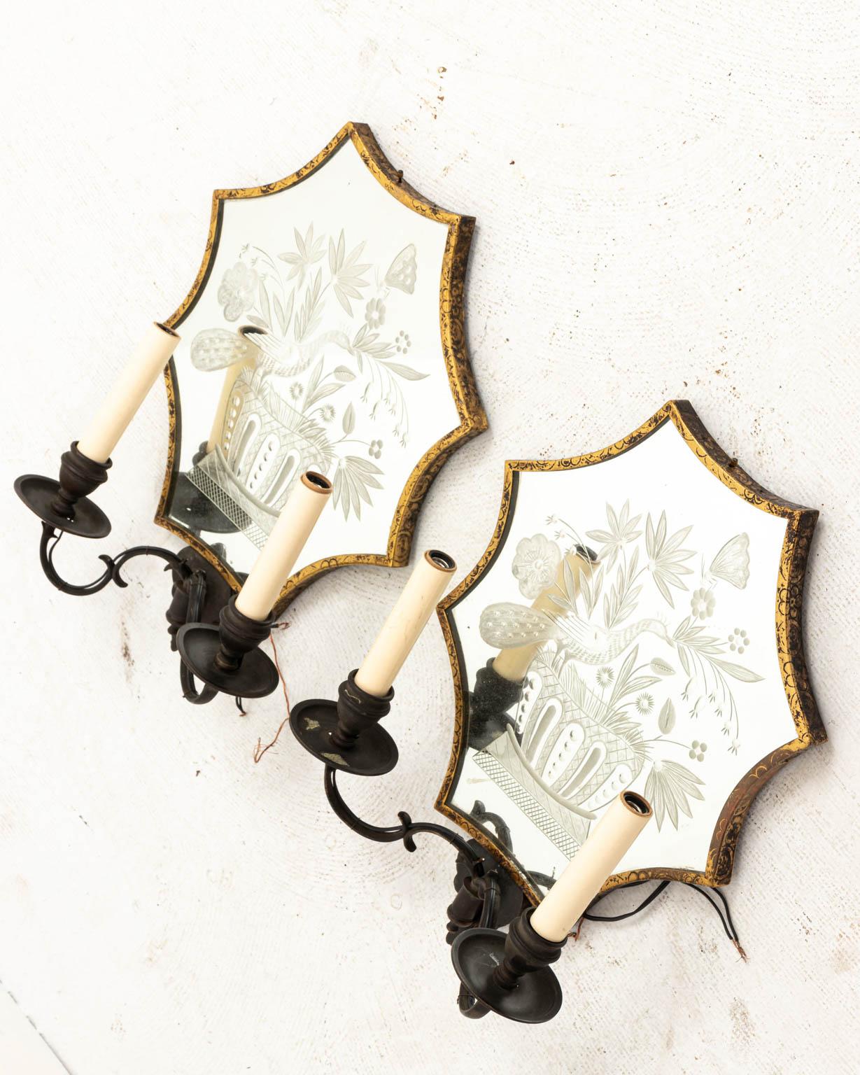 Pair of etched mirror sconces with birds, flowers, and butterfly motifs, circa 1990s. The piece also features oil rubbed bronzed metal and two arm lights. Wired. Please note of wear consistent with age including patina and oxidation to the metal