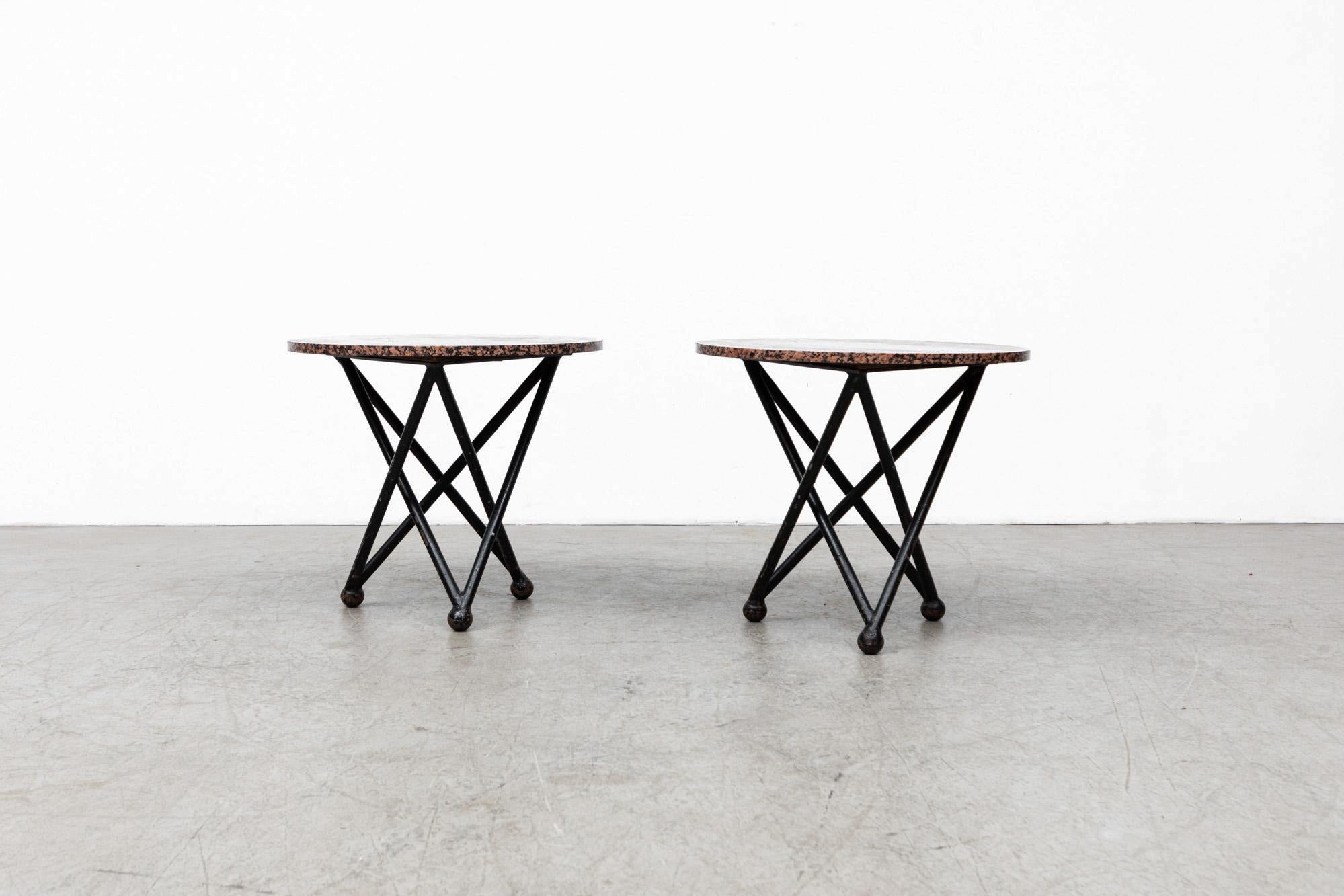Ettore Style red granite side tables with architectural metal bases. In original condition, with some wear to granite tops and metal bases, including chips and patina to the frames. Wear is consistent with age and use.