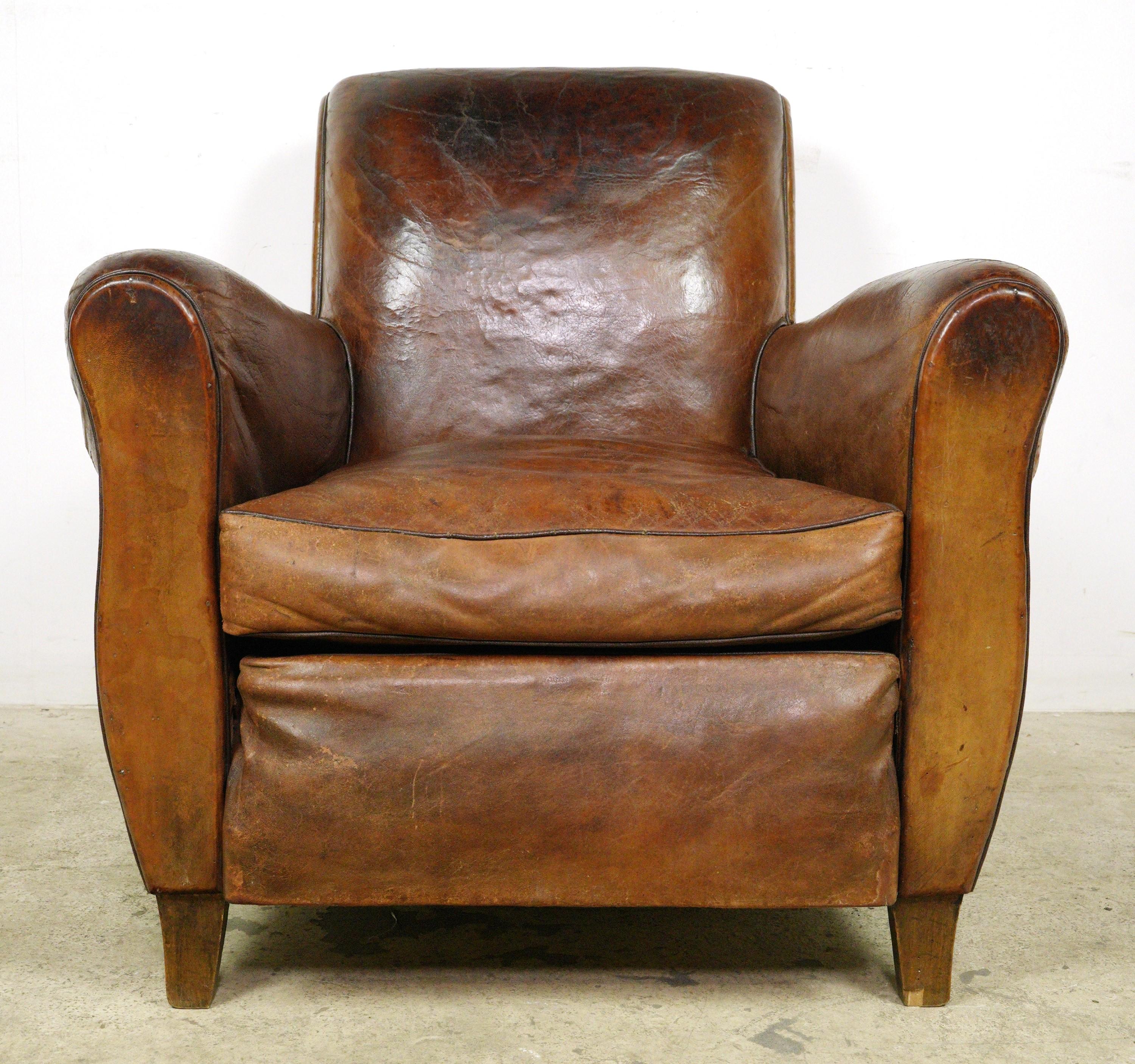 Brown leather club chairs made in France. Please refer to the pictures for a full view of the condition. Good condition nicely patinaed with surface wear from prior use. Priced as a pair. Please note, this item is located in our Scranton, PA