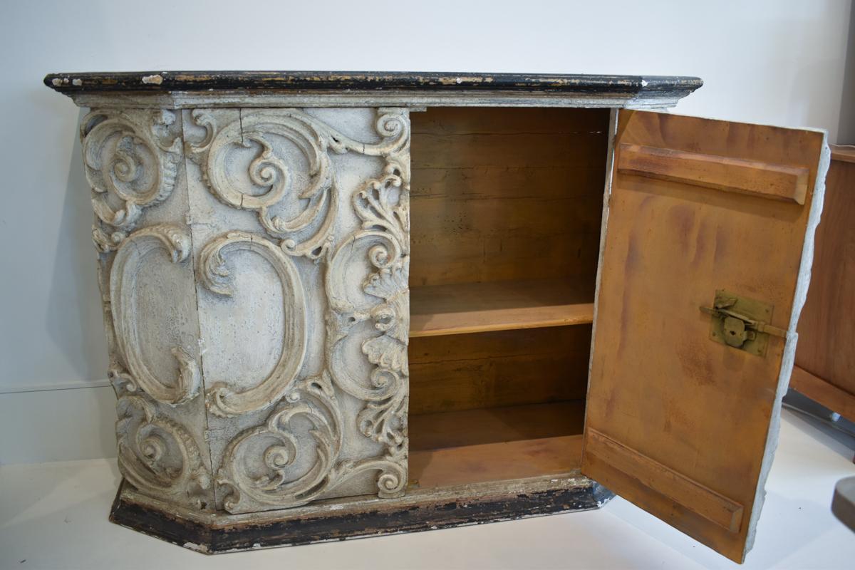 This striking pair of European mid-century buffets showcases a masterful blend of artistic craftsmanship and functional design. Each buffet is meticulously sculpted with intricate, ornate details that evoke a sense of old-world charm and
