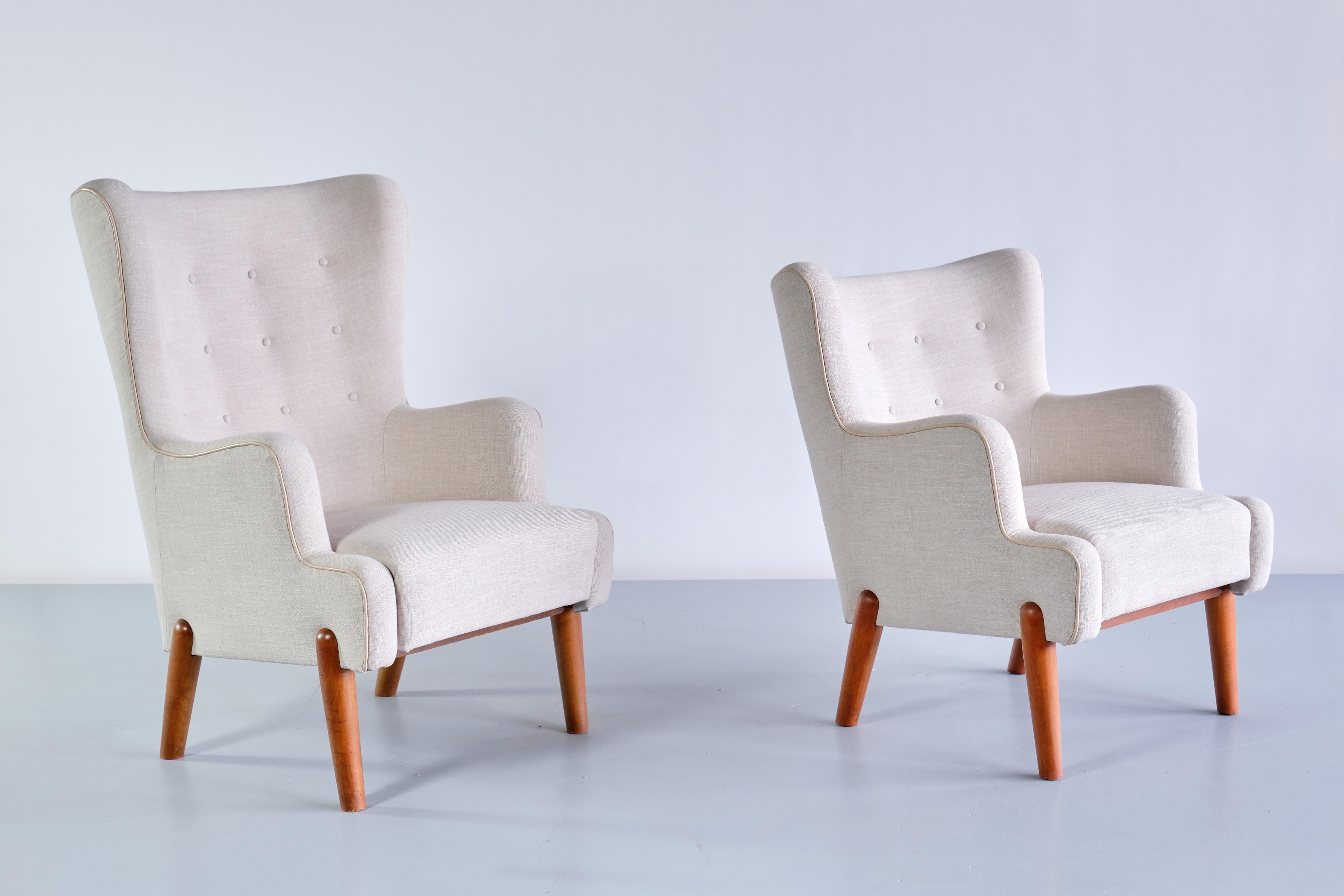 This rare pair of armchairs was designed by Eva and Nils Koppel and produced by Slagelse Møbelværk in Denmark, 1950s. This striking pair consists of a high back armchair and the same model with a lower back. The design is marked by the tiered levels