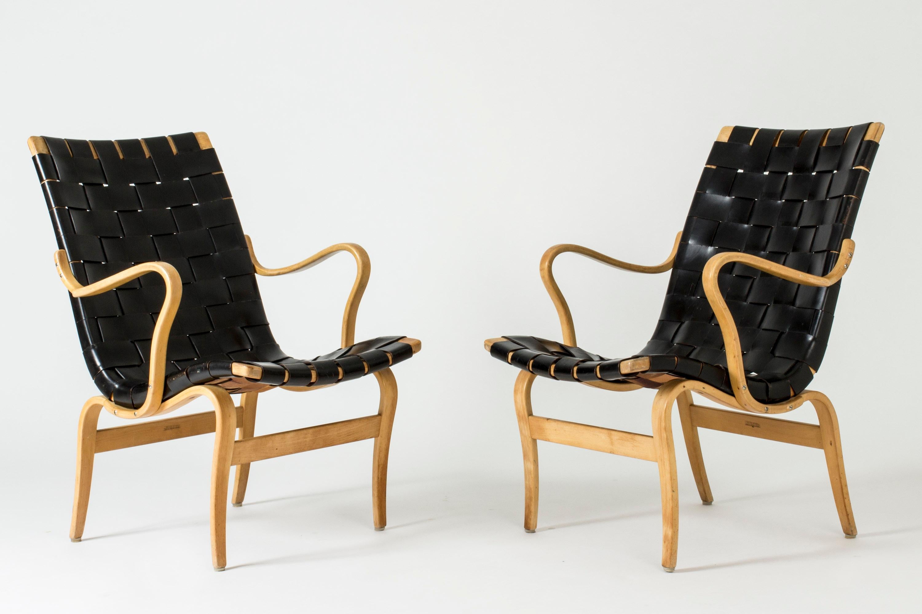 Pair of cool and comfy “Eva” lounge chairs, made from bentwood beech and wreathed black leather. Amazing silhouettes, beautifully aged leather.