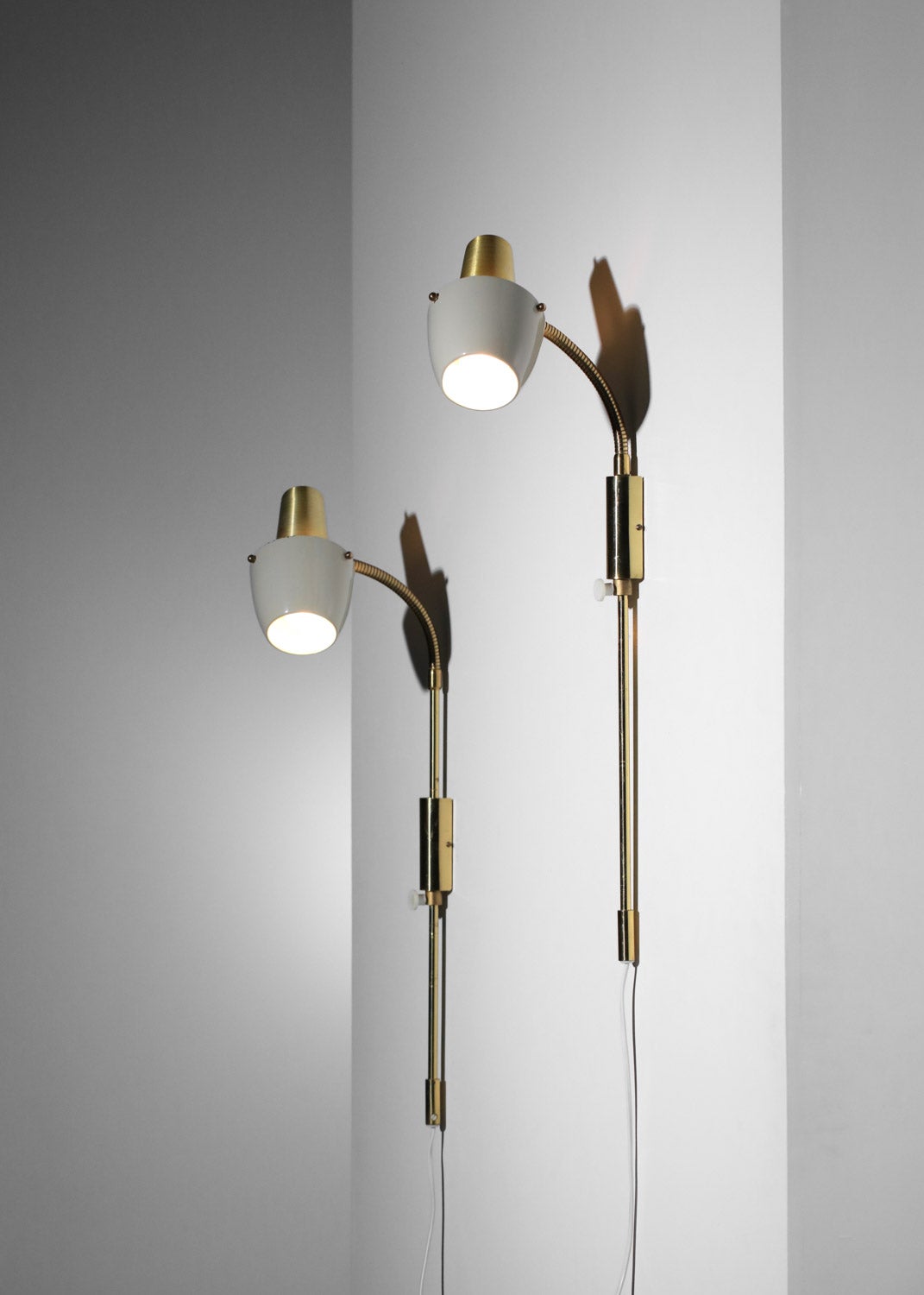 Coppia di applique svedesi anni '60 di EWA, modello V45. Struttura in alluminio dorato, paralumi in metallo laccato beige (vernice originale). Le tende possono essere ruotate in diverse posizioni e l'altezza può essere regolata sulla barra di