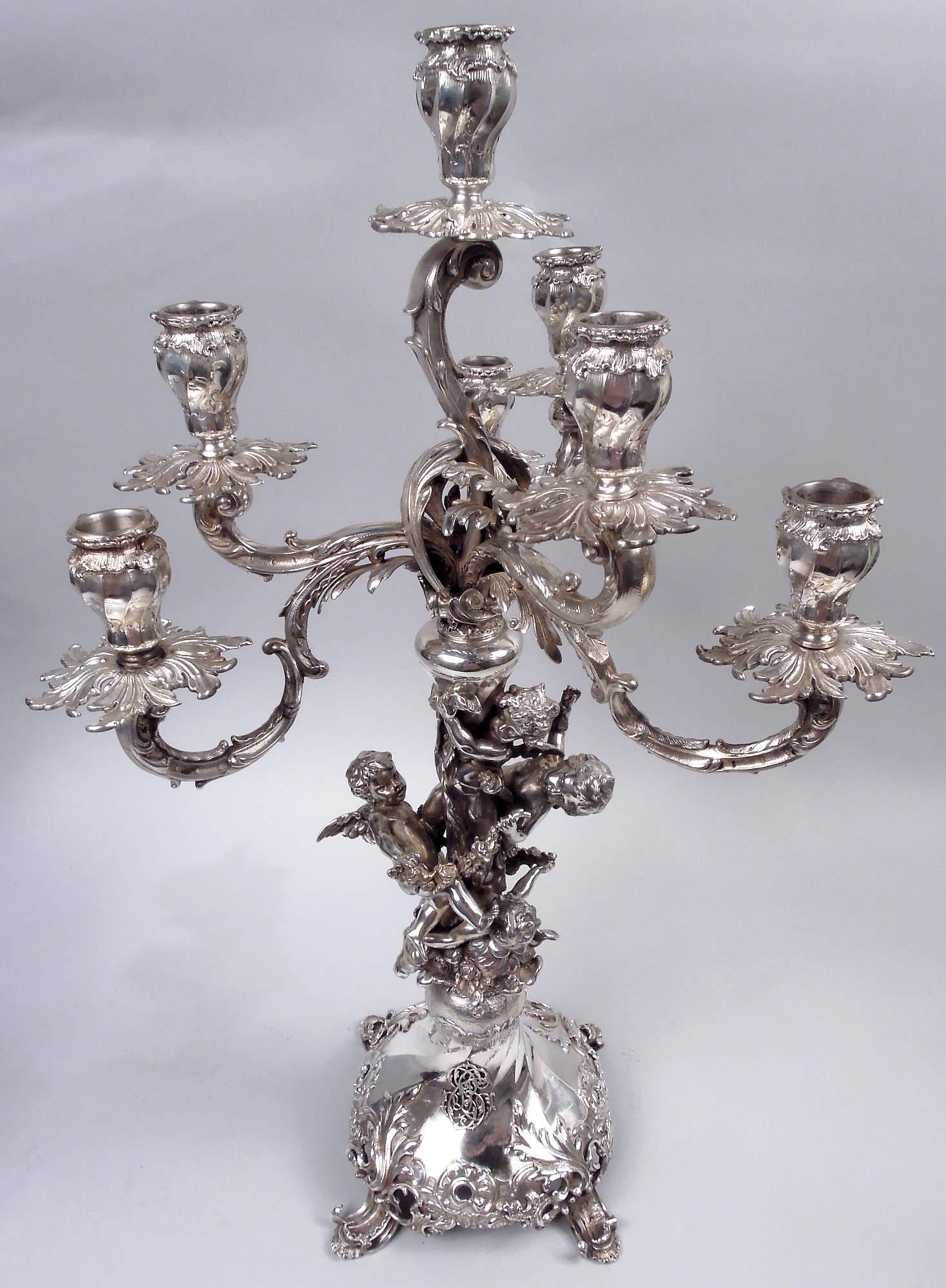 Pair of Austrian Rococo 800 silver 7-light candelabra, ca 1880. Each: Seven lights on leaf-capped scrolled arms thread-mounted to twisted-fluted shaft mounted to same domed foot with applied leafing scrollwork; four splayed leafing scroll supports.