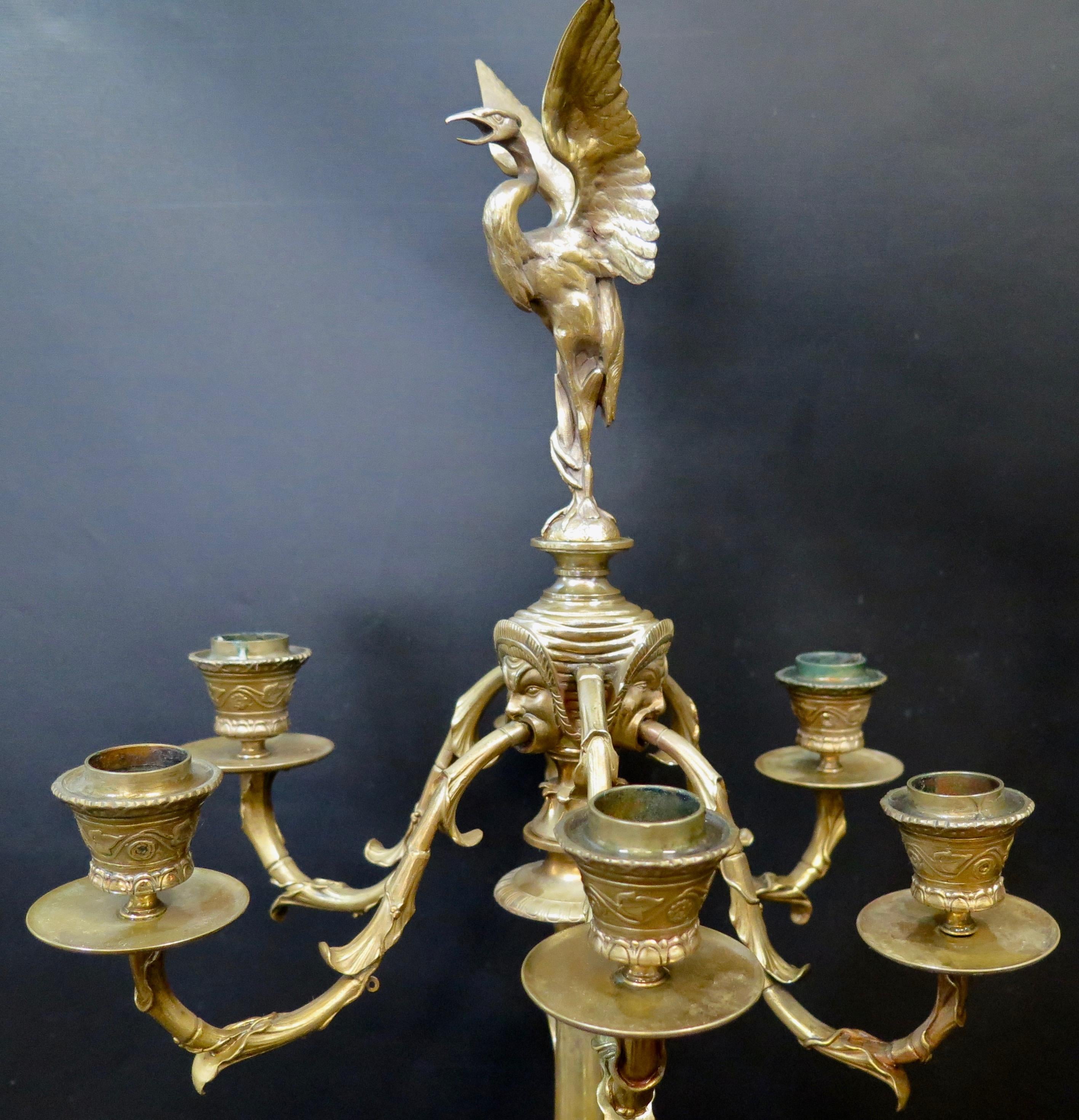 This exceptional high quality pair of French 19th century tall bronze candelabra are magnificently sculpted. A figural mythological animal tripod base holds a tall bamboo stem flowing upward. Six decorative extended curved arms terminate in candle