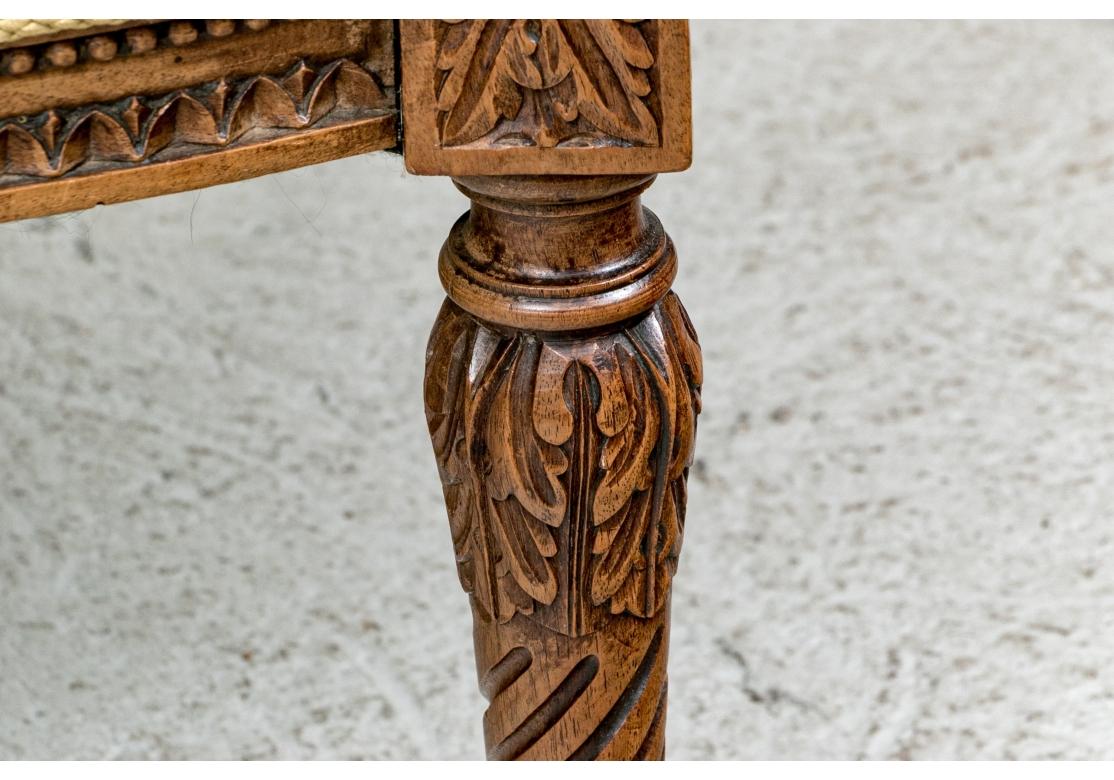 Paire de chaises à dossier en forme d'aile avec des cadres solides et robustes lourdement sculptés de fleurs en forme de cloche, d'œufs et de motifs feuillagés. Les chaises à dossier et assise fixes, manchettes, sont tapissées sur mesure d'un tissu