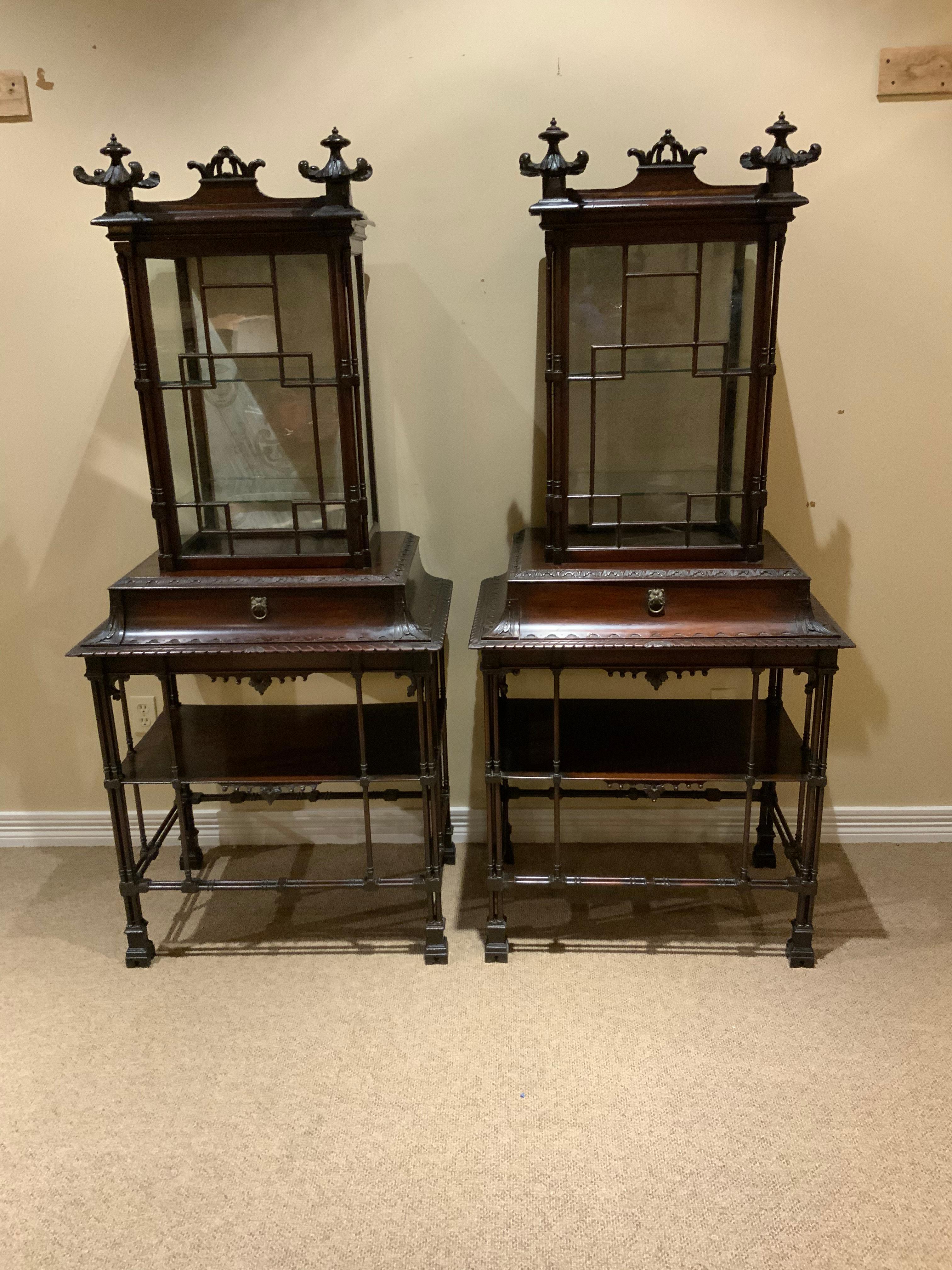 Pair of display/vitrine cabinets in the Chinese Chippendale taste, finely 
Crafted by a gifted cabinet maker in mahogany. Highly stylized and carved
With pagoda carved finials at the front crest of these impressive pieces.
Glazed on three sides