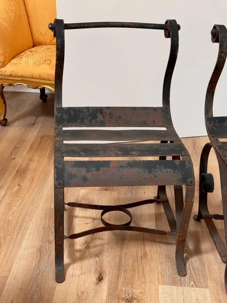 Paar eiserne Park-Sessel aus der Mitte des Jahrhunderts mit verschnörkelter oberer Schiene und Sitzfläche aus Gurtband, schwarz lackiert. 32 1/2 x 19 1/4 x 22 in. (82,6 x 48,9 x 55,9 cm.)