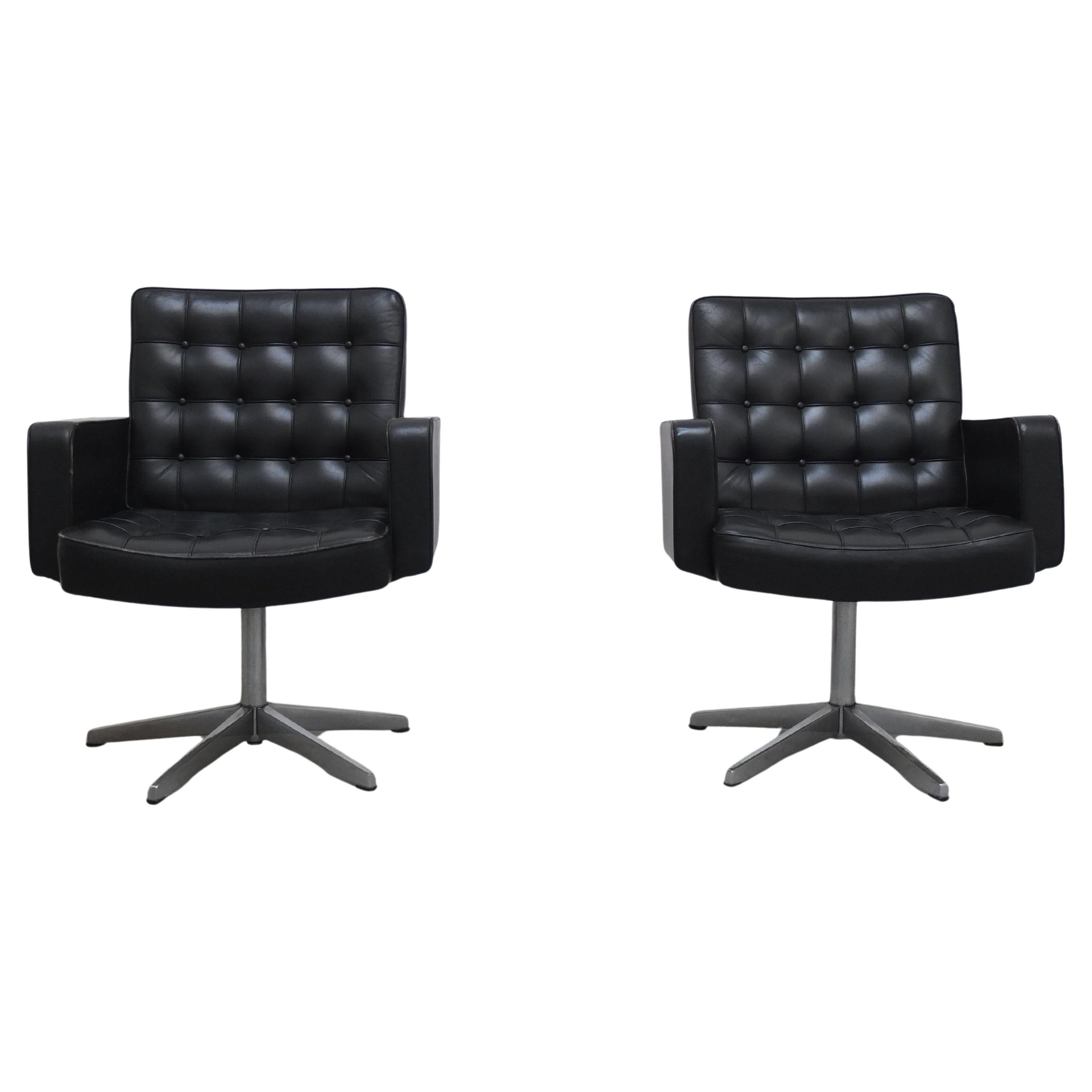 Paire de fauteuils de salon haut de gamme conçus par Vincent Cafiero pour Steele vers 1960, recouverts de cuir noir boutonné d'origine et reposant sur un piètement pivotant en acier poli à cinq points. Ces modèles sont produits dans les années 1960