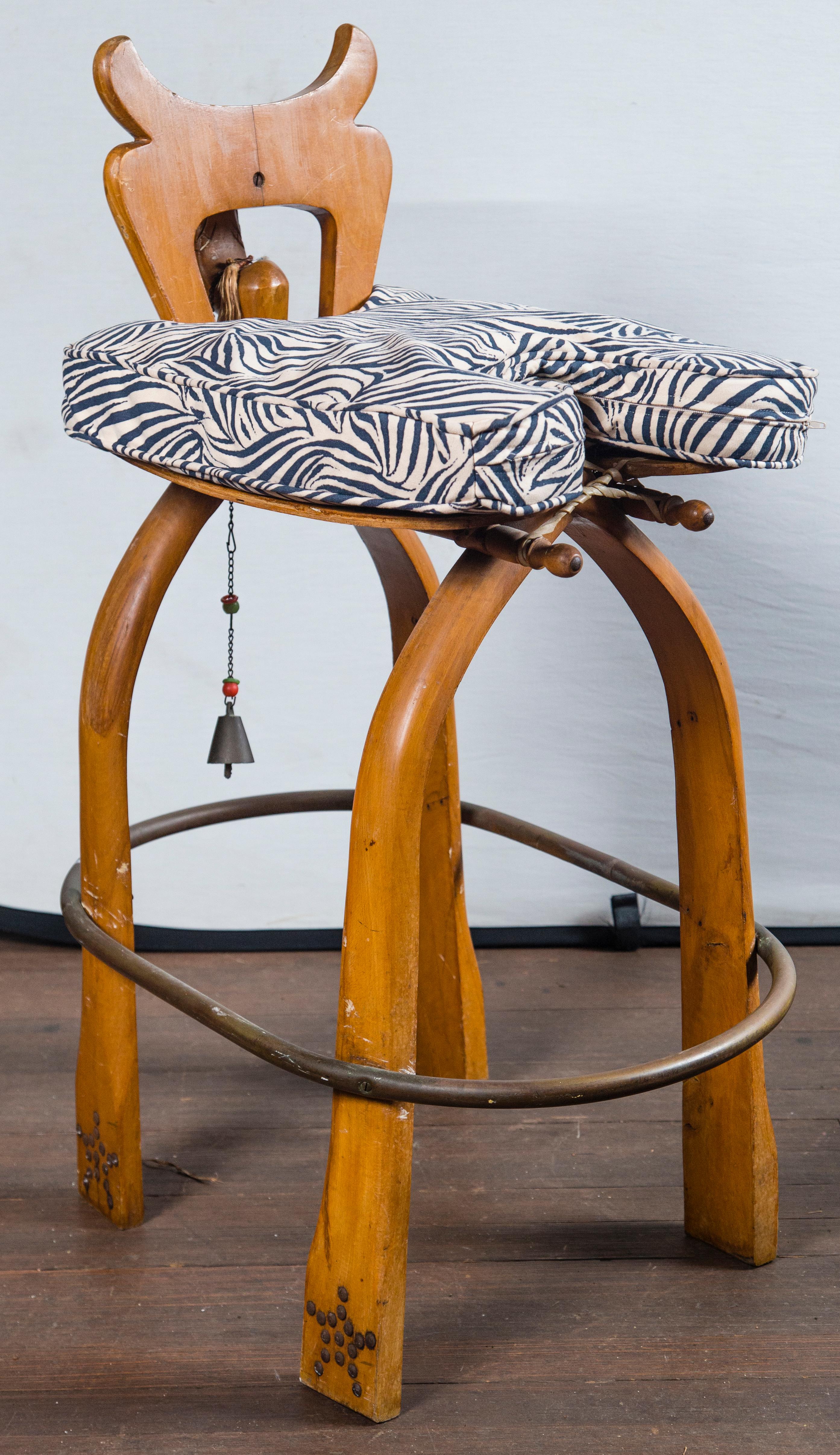 Unusual carved camel head bar stools. Seat: 15 inches wide, 16 inches deep. Stylized zebra fabric cushions.