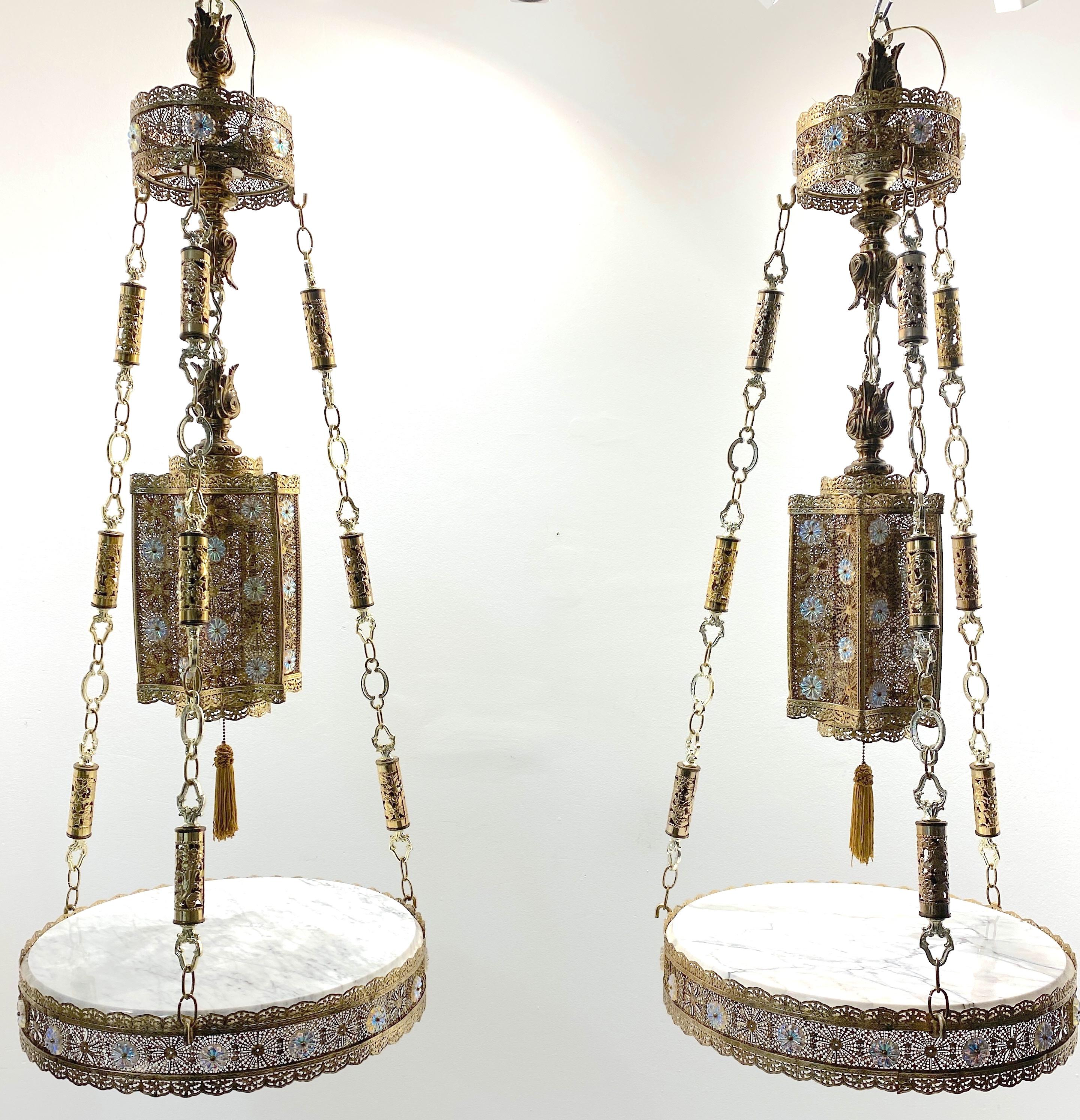 Pair of Exotic Moorish Hanging Brass & Crystal Lantern & Marble Side Tables 
Italy, Circa 1960s

A pair of Exotic Moorish Hanging Brass & Crystal Lanterns with Marble Side Tables, originating from Italy in the 1960s. This glamorous duo presents a