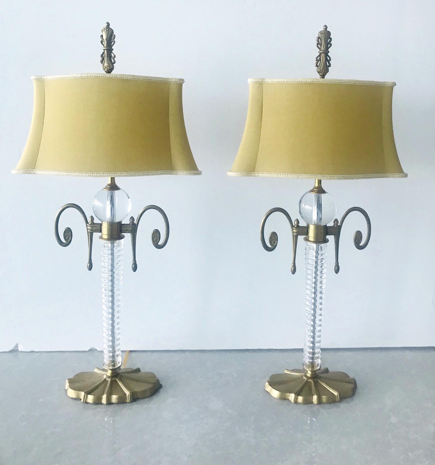 Pair of elegant vintage Art Deco lamps with blown fluted glass stems and large glass ball details. The lamps have gorgeous brass scrolls and fittings with incised floral designs. The base is comprised of cast iron metal with gold leaf finish and Art
