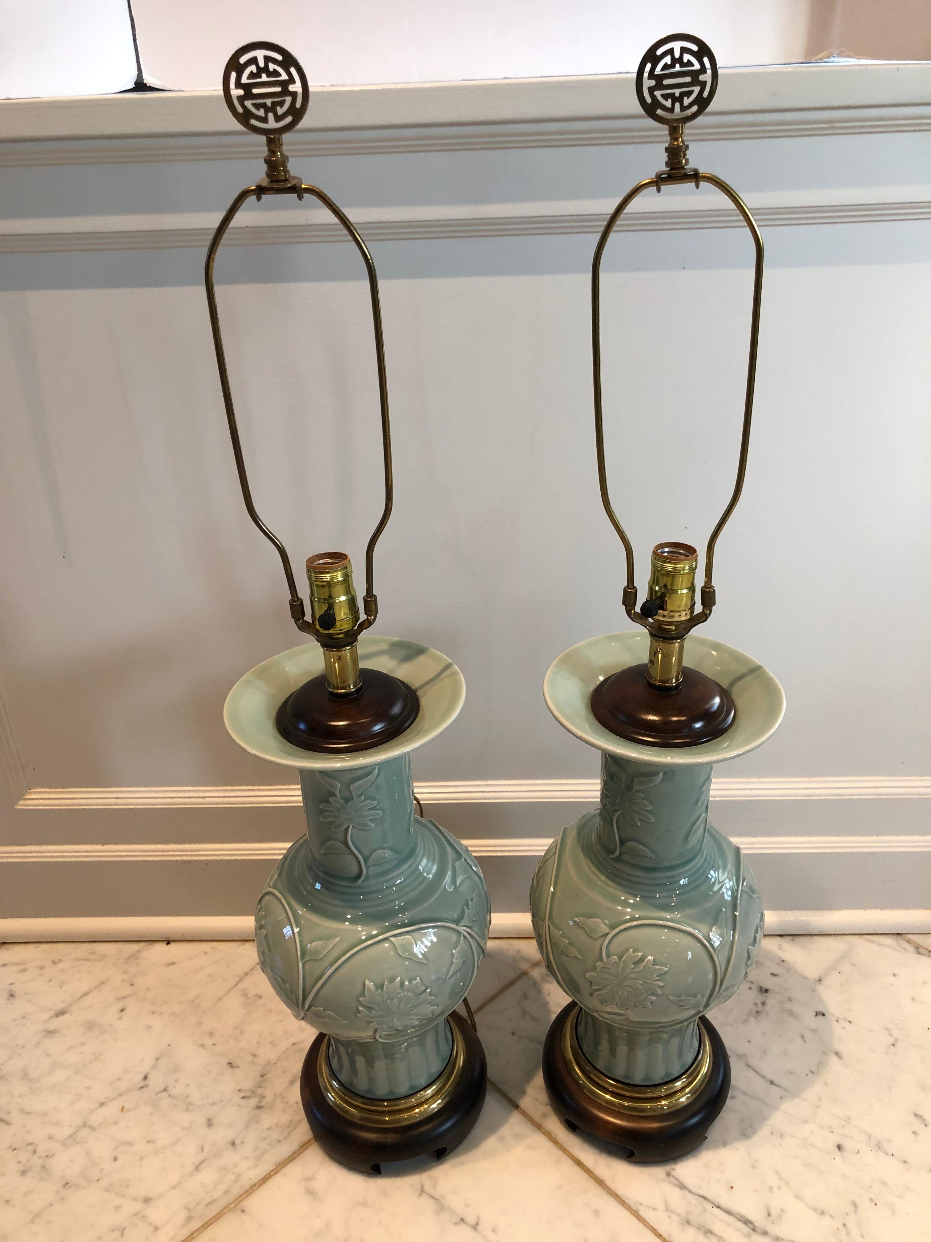 Pair of beautiful celadon table lamps by Frederick Cooper having an embossed floral design and resting on rosewood bases. Brass finials have an Asian design. Marked Frederick Cooper. No shades.