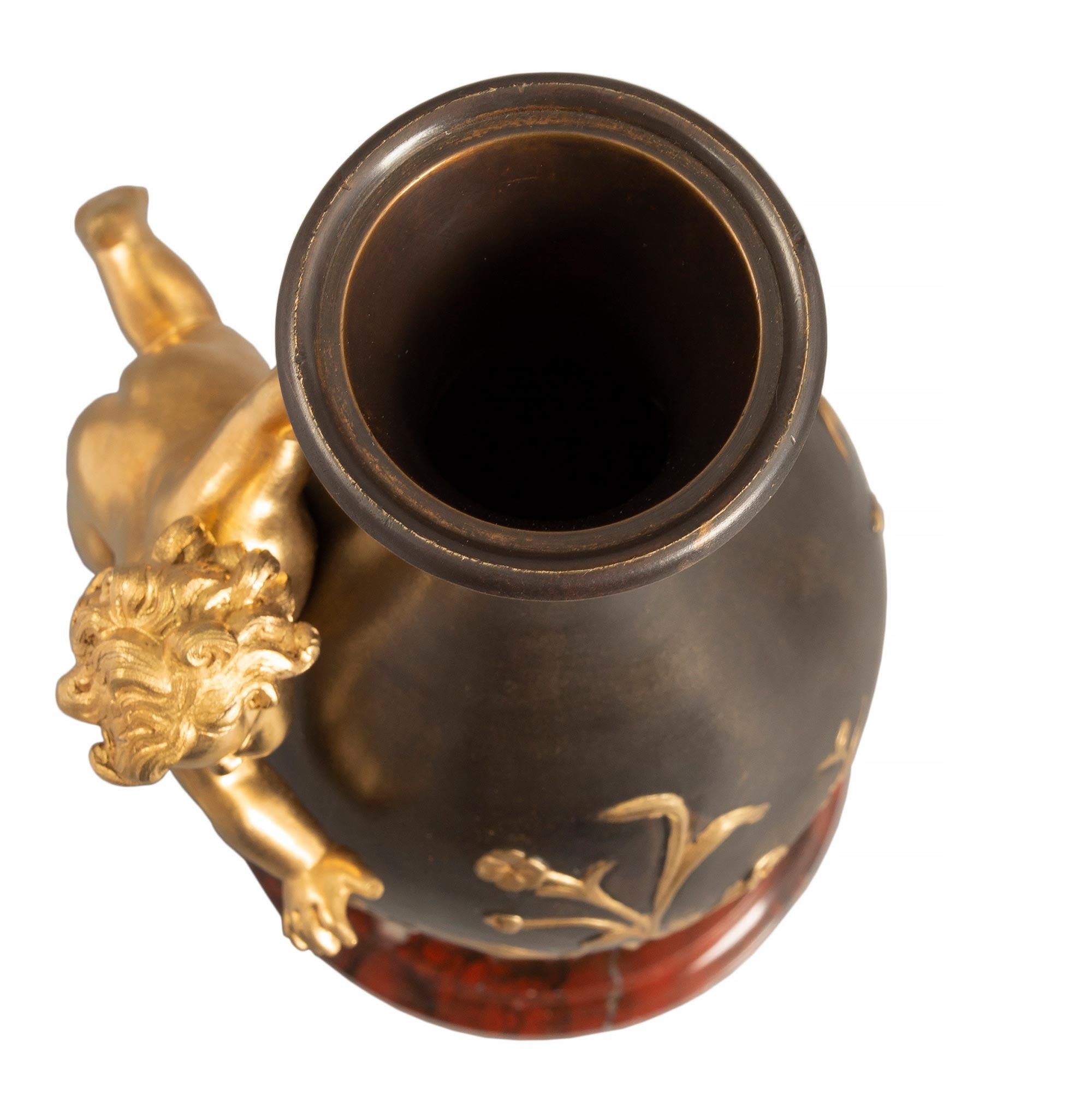 Ein Paar exquisite französische Vasen aus patinierter Bronze und Ormolu aus dem Louis XVI Jahrhundert, die Moreau zugeschrieben werden. Jede Vase steht auf einem runden Sockel aus Rouge Griotte-Marmor mit gesprenkeltem Rand. Über einer geriffelten