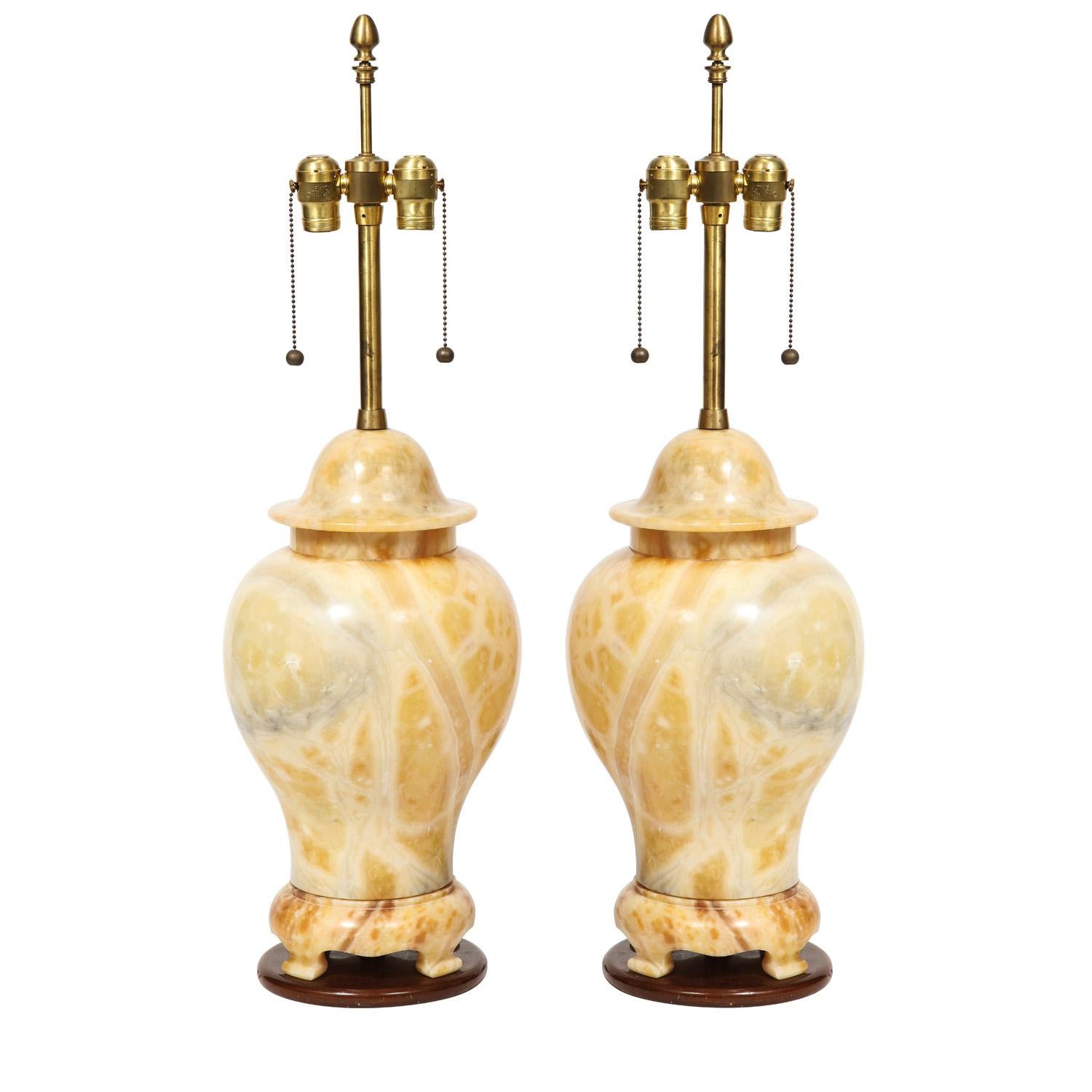 Pair of artisan table lamps, ginger jar design in solid figured yellow marble with brass hardware on dark wood bases, Italian 1960's. The craftsmanship in making these lamps is superb. The coloration is stunning.

Diameter: 9 inches
Height: 33