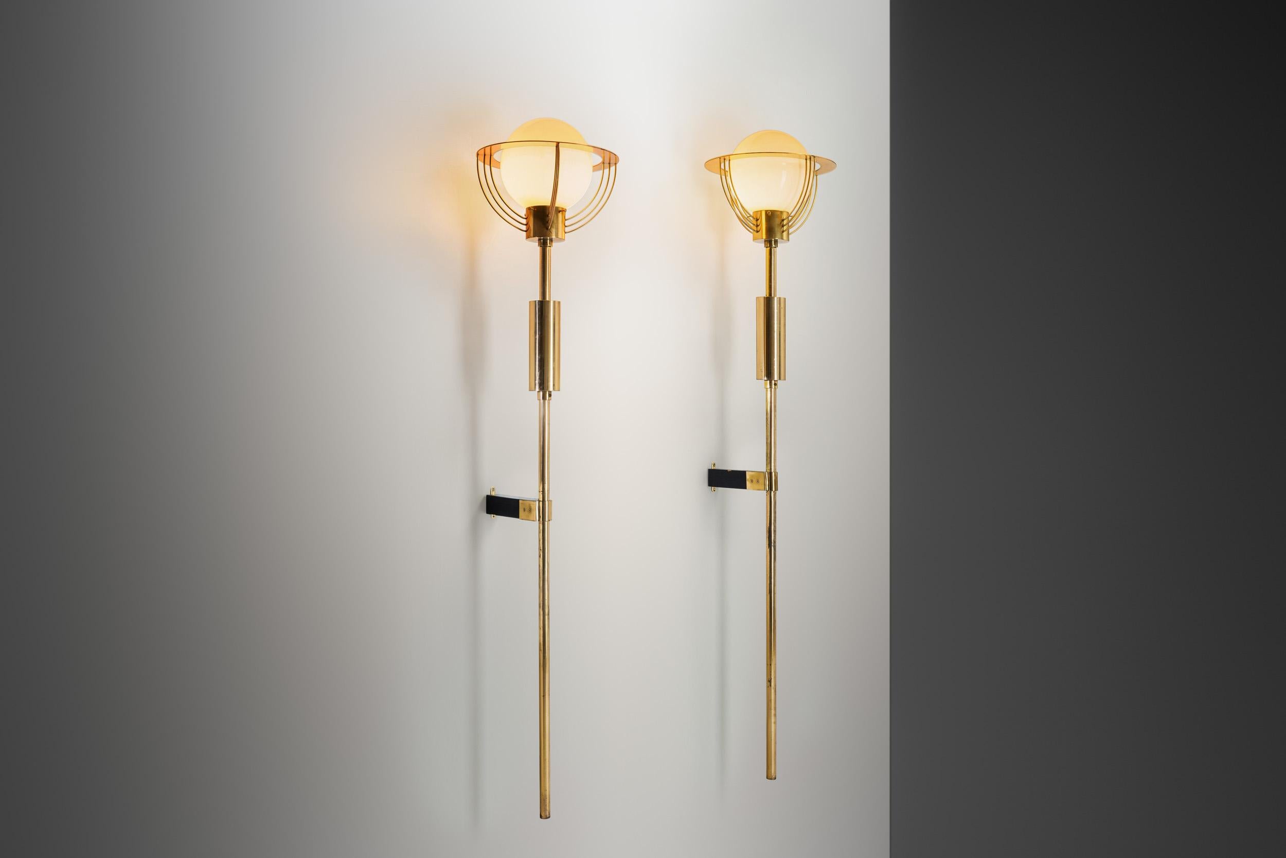 The mid-20th century brought about a revolution in design throughout Europe, where function and form merged in the most intriguing ways. One such example of this era’s creativity is this pair of exceptionally unique and large wall lamps. This pair
