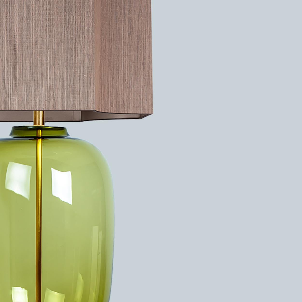 A unique Minimalist timeless design. Each extra large glass table lamp features a green exceptional transparent shaped base with a solid walnut wooden foot with old brass accents and a brass rod running through the center. Enhancing the light and
