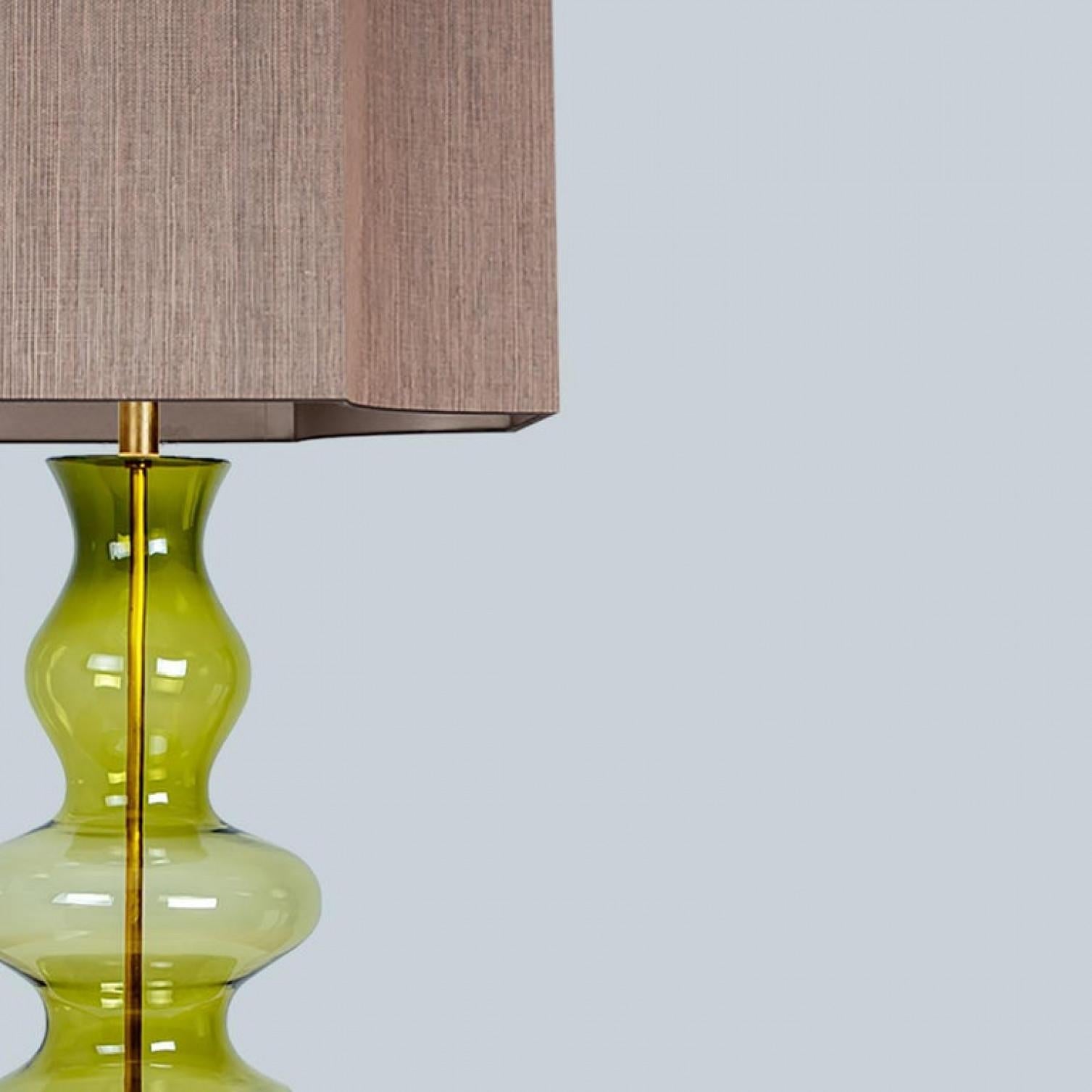 A unique Minimalist timeless design. Each extra large glass table lamp features a green exceptional transparent shaped base with a solid walnut wooden foot with old brass accents and a brass rod running through the center. Enhancing the light and