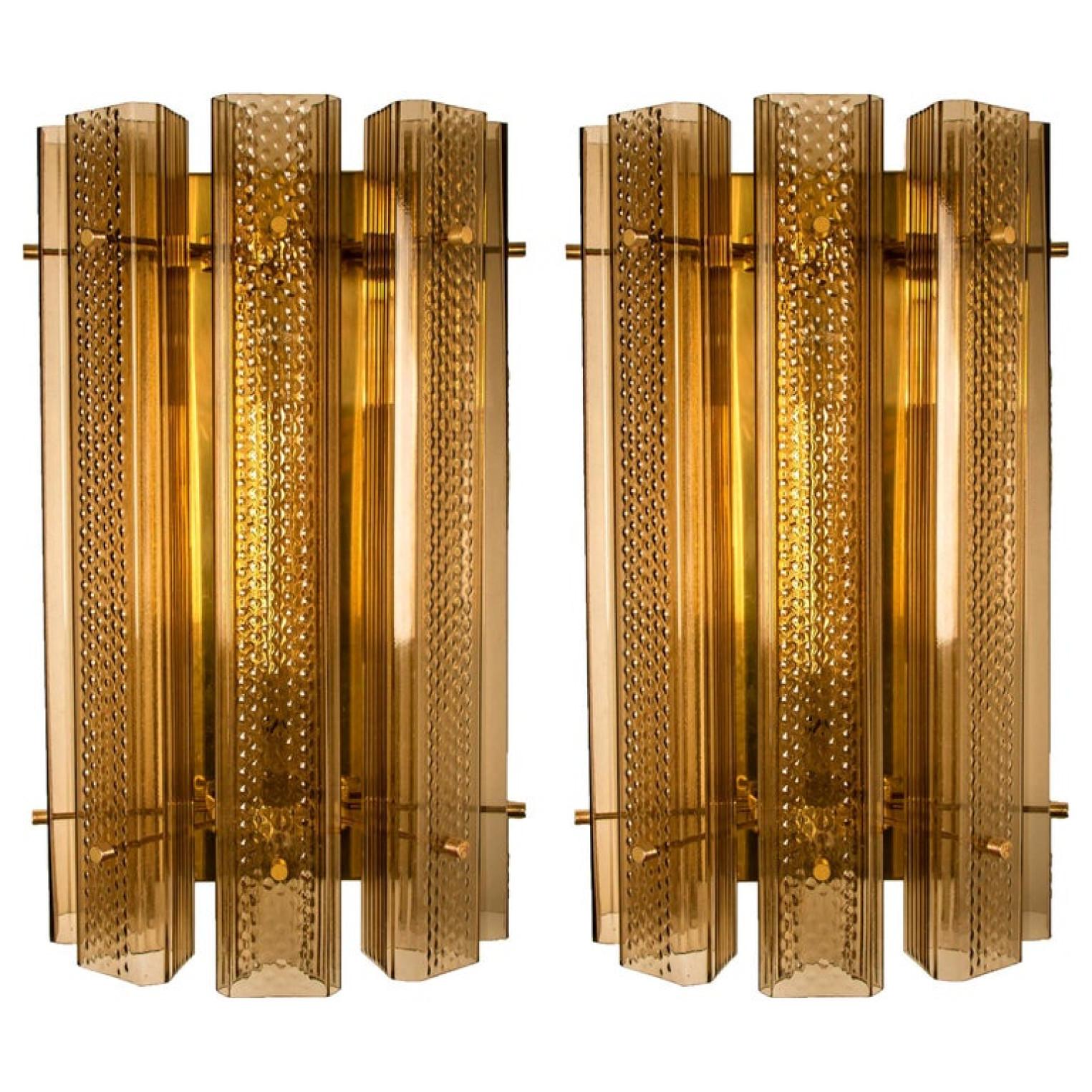 Pair of wonderful extra large Murano wall sconces, manufactured in the 1970s. The lights feature a brass frame with five large Murano square tubes in clear and smoked textured glass. With brass details. The tubes diffuse the light beautifully to