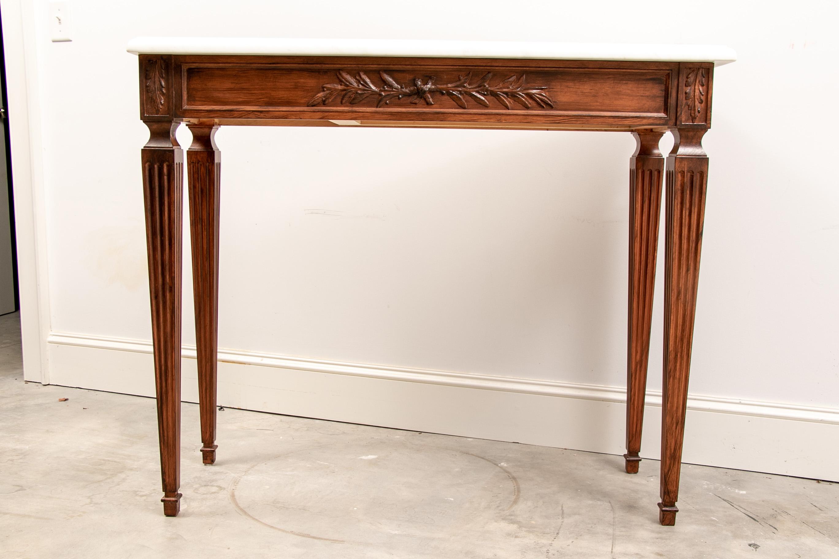 Pair of extraordinary custom Regency style marble top consoles, beautifully crafted and finished pair of custom made consoles in Regency style. Tables feature tapering receded legs, acanthus leaf and foliate accents, hidden side drawers, finished