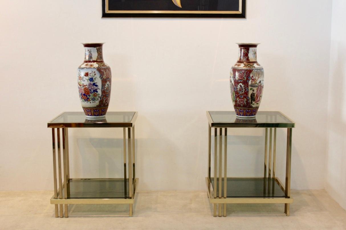 Sophisticated set of French side tables with a stunning brass frame with a beautiful graphical design. The solid and glossy square shaped tables with beautiful Brass accents has two tier green smoked glass. The tables are a unique example of the