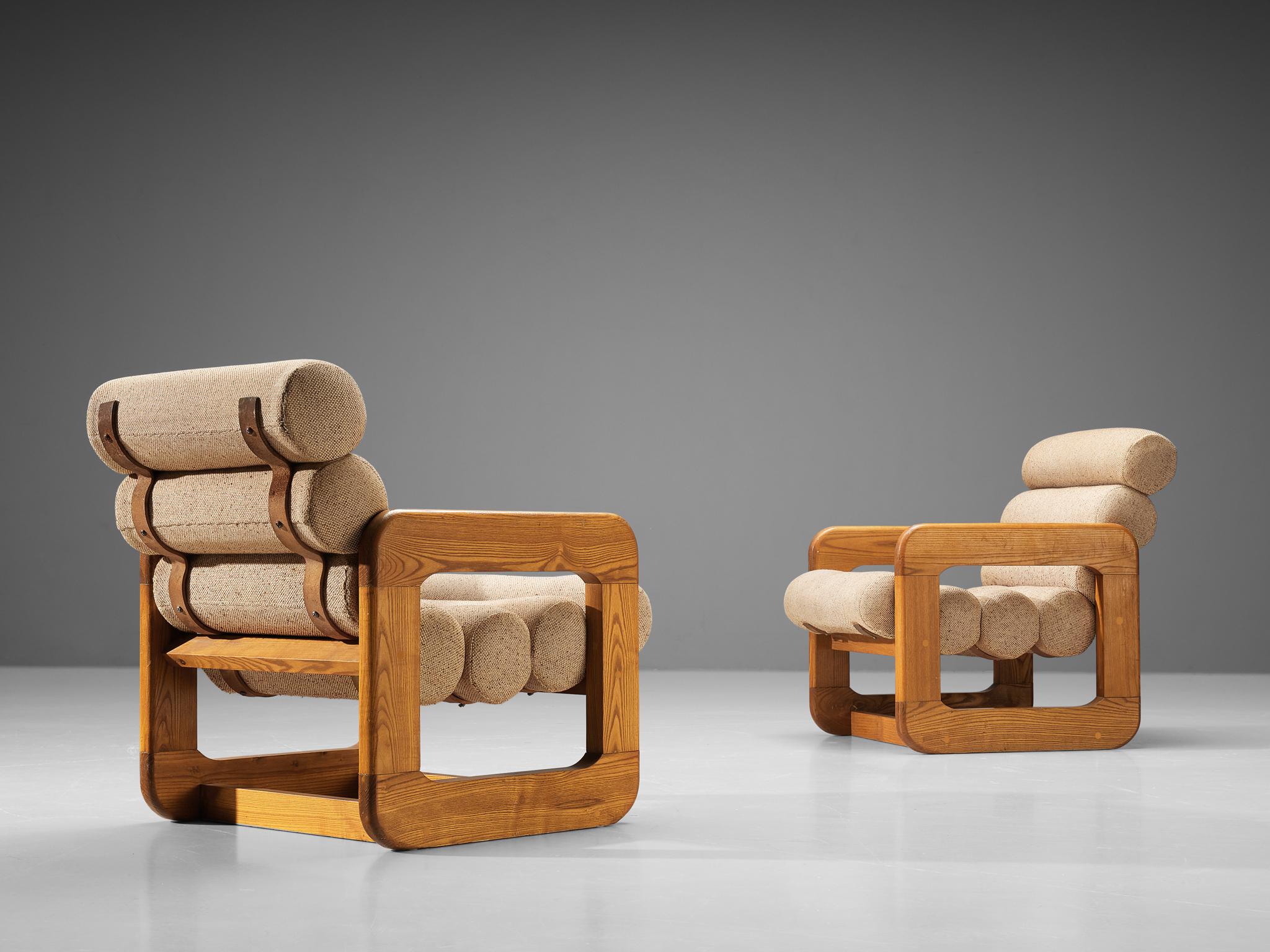Lounge chairs, ash, fabric, Europe, 1970s. 

Pair of two unconvential lounge chairs that feature an outstanding design. The seating contains multiple tube-shaped cushions attached together to create a seat and backrest. The repetition of the