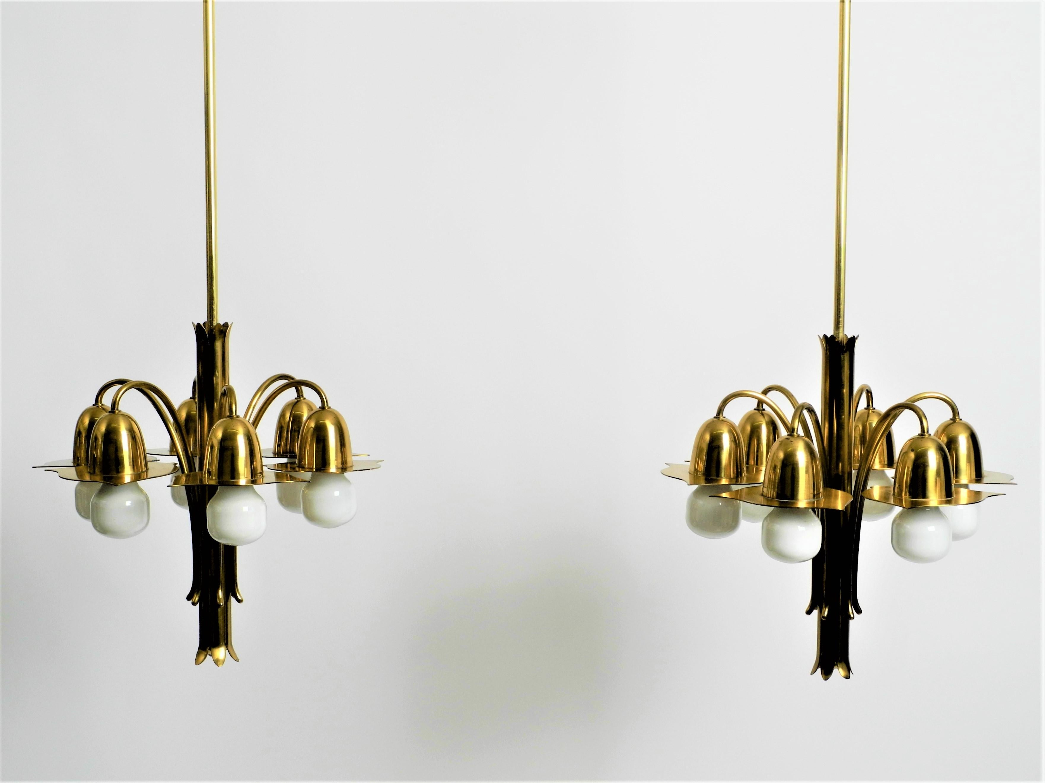 A pair of extraordinary Art Nouveau chandeliers made of brass with long brass rods. The chandeliers were designed by the Munich Art Nouveau designer Richard Riemerschmid. Until recently, both chandeliers were owned by the Riemerschmid family. 

The