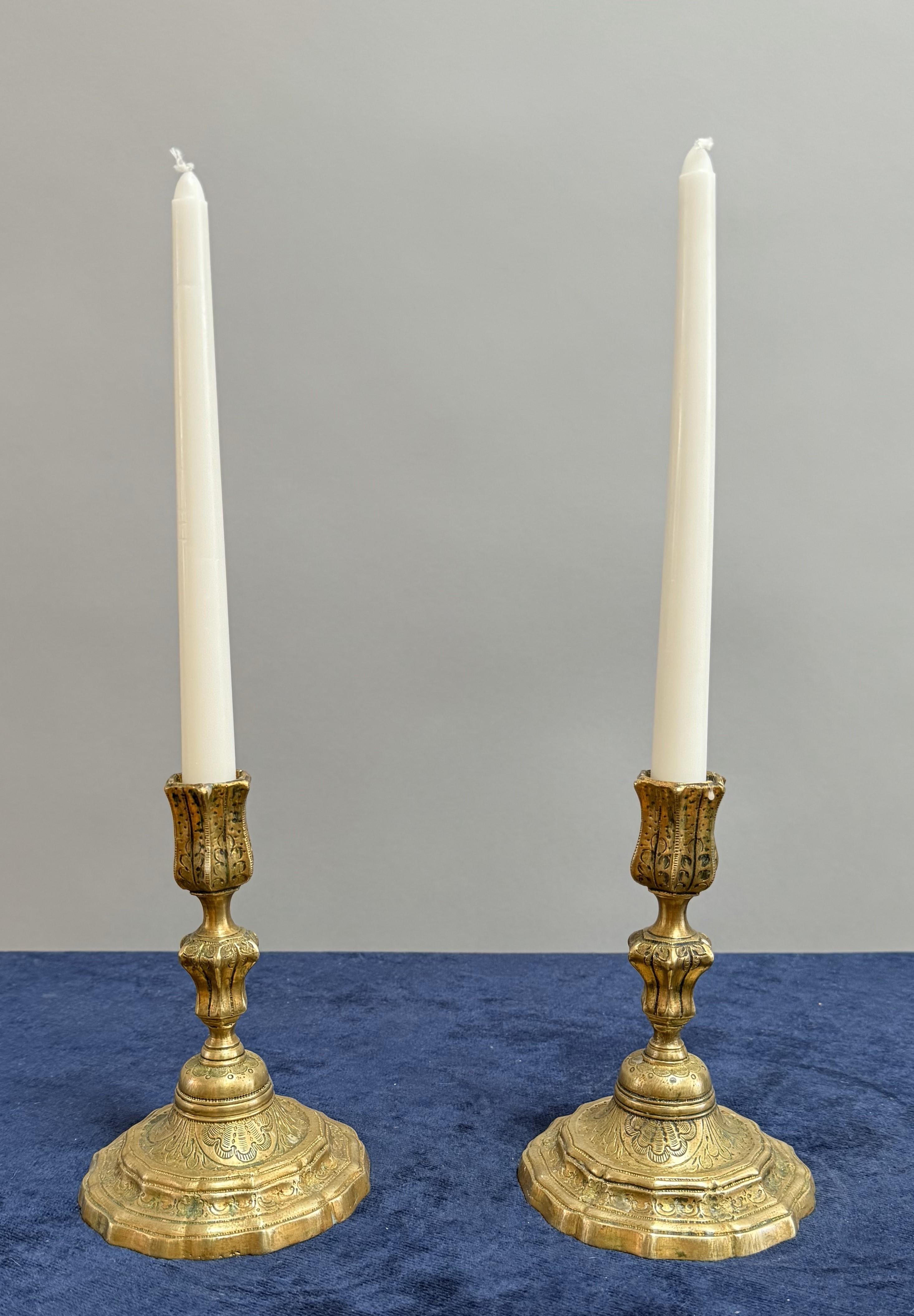 Made of gilded brass with intricate incised decoration on delicate molded stems with flanged bases. Comes as a pair. Dated 1717 Ile de France.
There is a date of 1717 scratched into the base of one of these candlesticks.

These brilliantly detailed