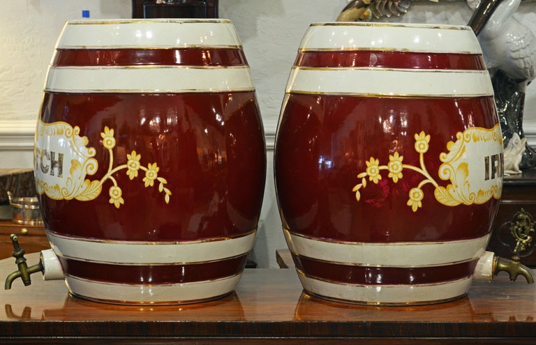 Beautifully glazed in white and burgundy trimmed with worn gold these whiskey barrels set the Ambience of a traditional English pub. They would look great in any home bar. Judging from the decorative wear to the gilt trim these barrels were like