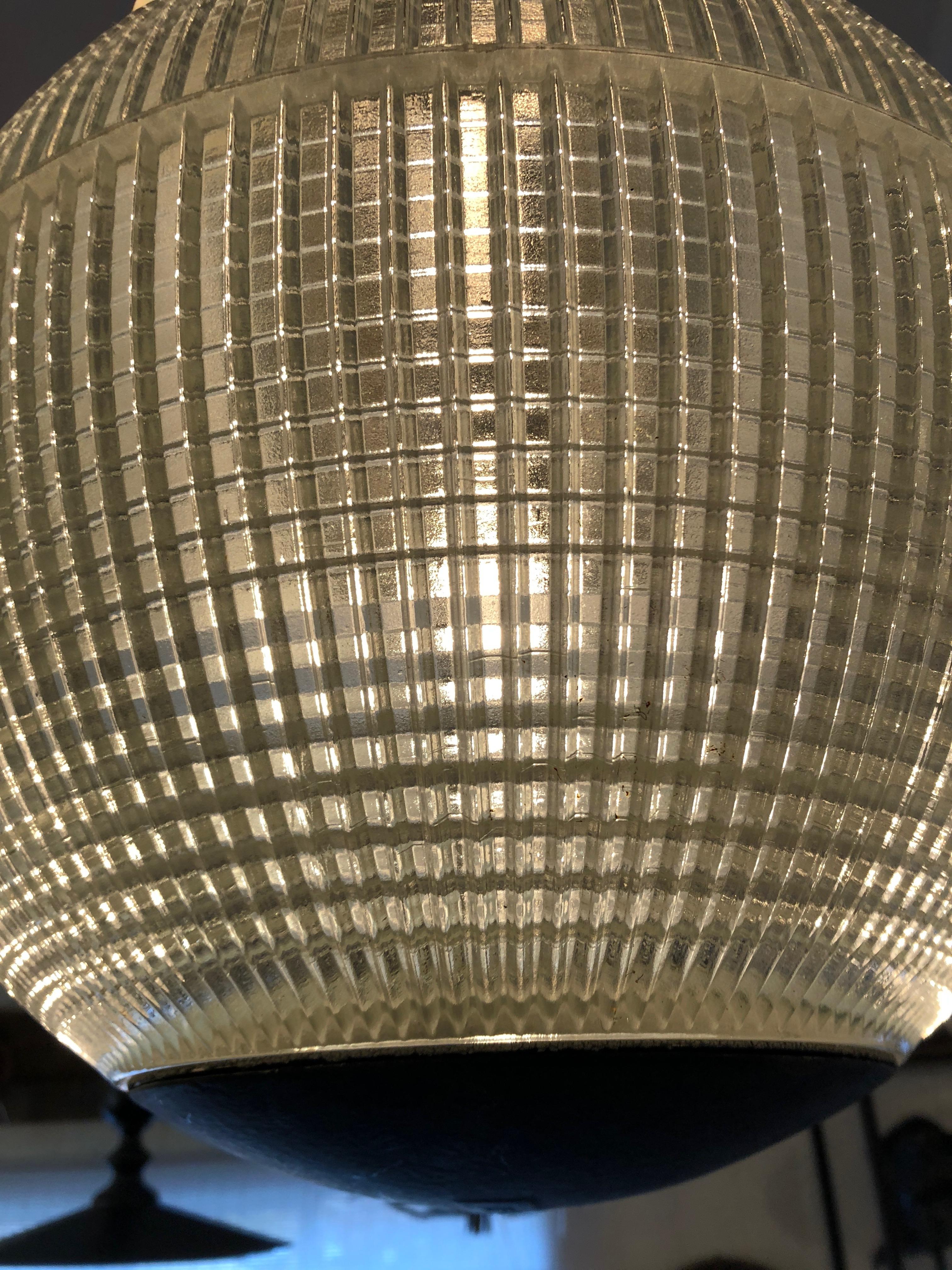 Fabulously glamorous pair of globe like holophane pendants made from Parisian streetlights. The hallmark of holophane luminaires or lighting fixtures, is the borosilicate glass reflector or refractor. The glass prisms or ribs provide a combination