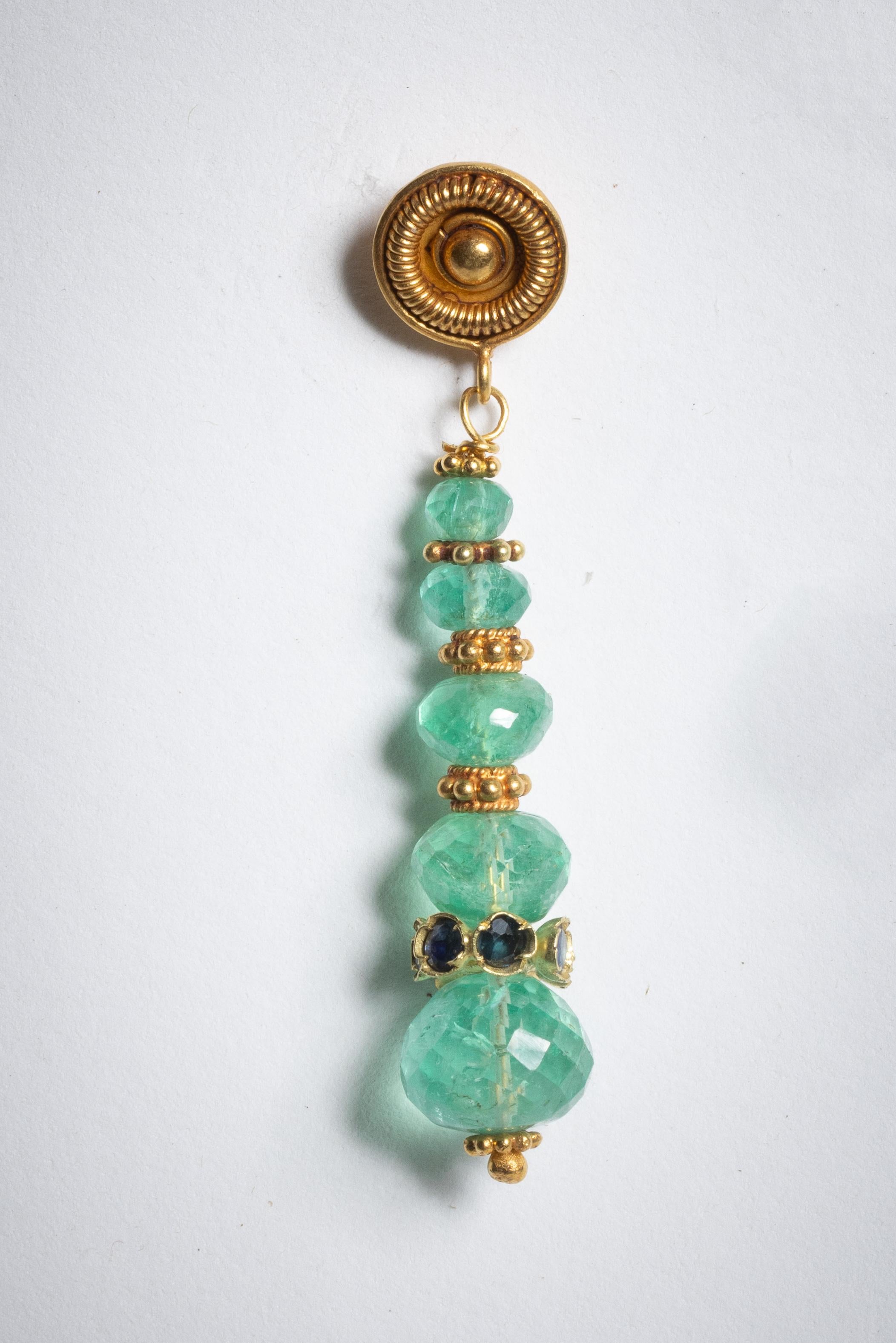 A pair of graduated and faceted Colombian emeralds with faceted sapphire rondelle above the last stone and 22K gold spacers.  22K gold post for pierced ears.  By Deborah Lockhart Phillips.

The fine jewelry collection is sourced, designed or created