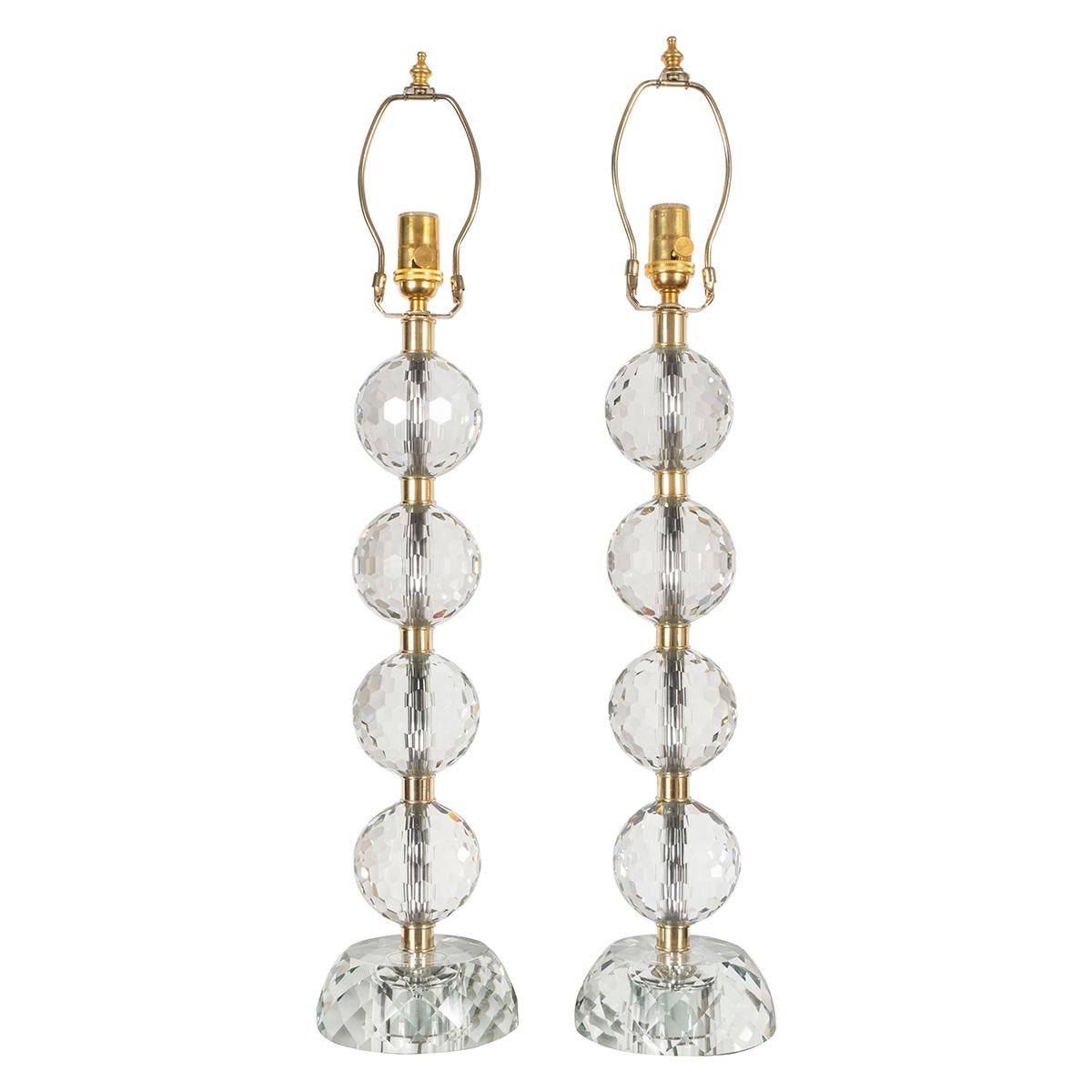Pair of table lamps composed of stacked faceted glass spheres with faceted glass bases and brass hardware.