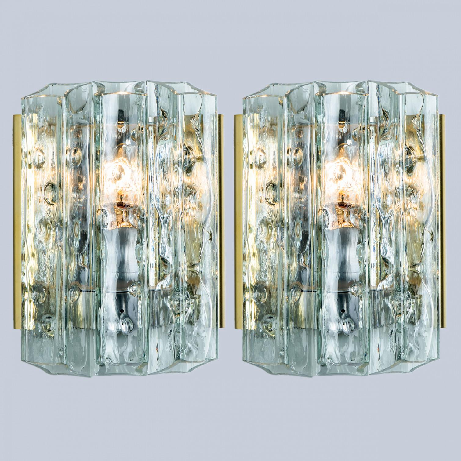 Pair of wonderful hand blown Doria wall lamps. Manufactured in the 1960s. With textured and clear and gold structured glass pipes.
The stylish elegance of this lamp suits many environments, from mid century to Hollywood Regency, from Danish modern