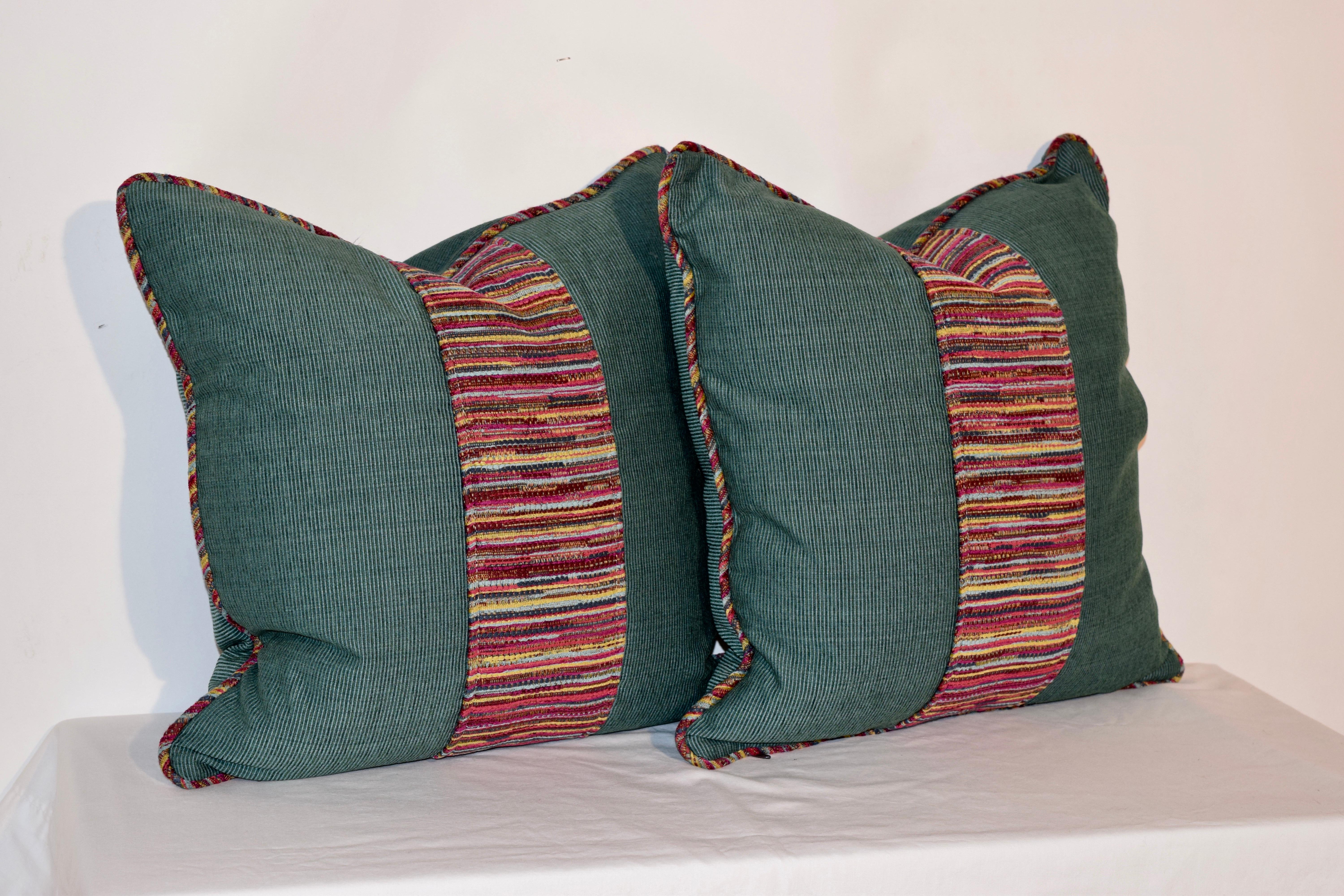 Handmade pillows with teal faille fabric and a central woven fabric stripe and matching welt. The back panels are solid teal faille fabric. The covers have hidden zippers and the feather inserts are removable. Dry clean only.