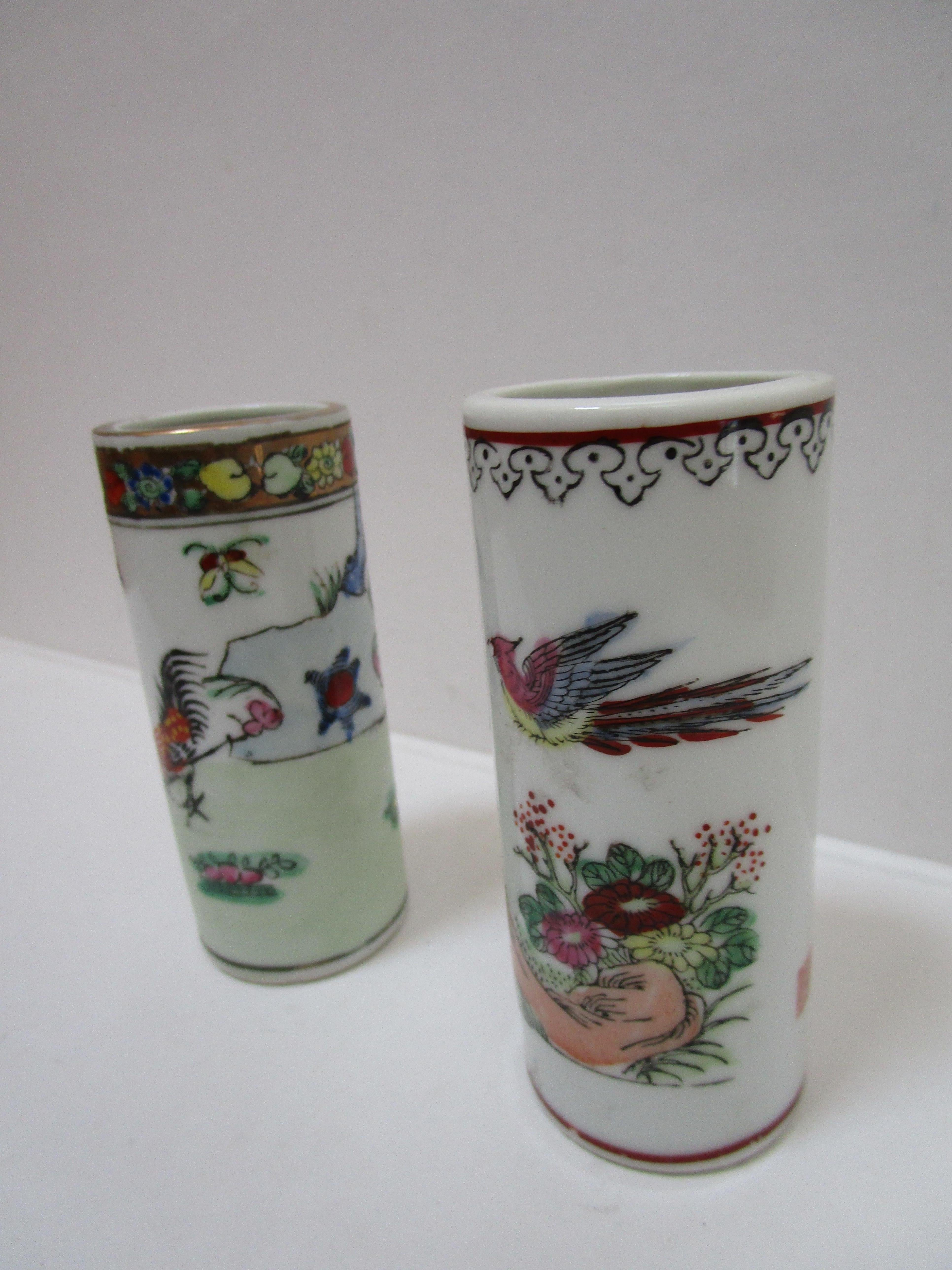 One of the pieces in this famille rose pair of brush pots bears an iron red square hallmark, as well as four columns of Chinese characters in a poem. The design that encircles the pots feature various flowers, two roosters on the ground on one and a