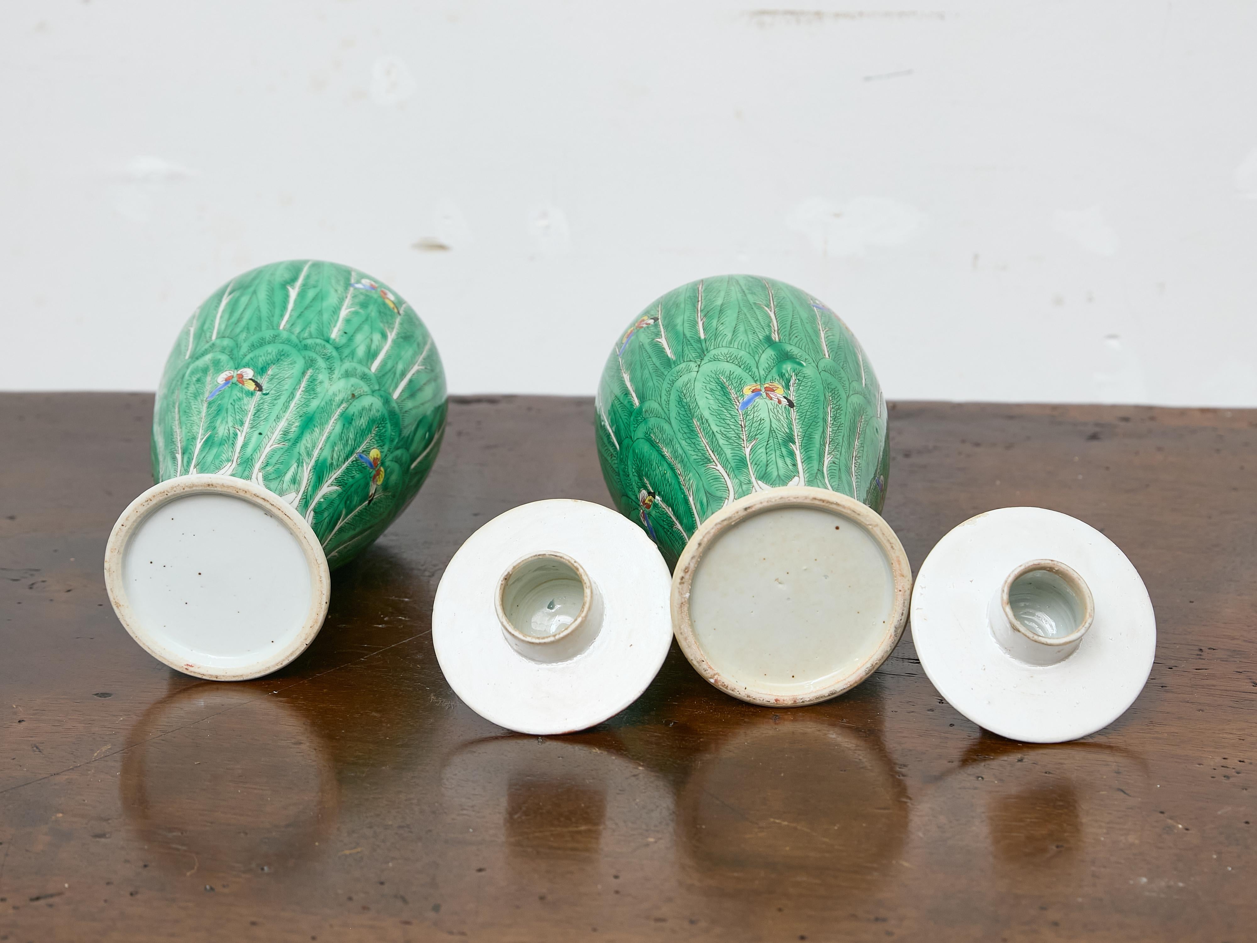 Porcelain Pair of Famille Verte Lidded Vases with Butterflies and Lion Finials, circa 1920 For Sale