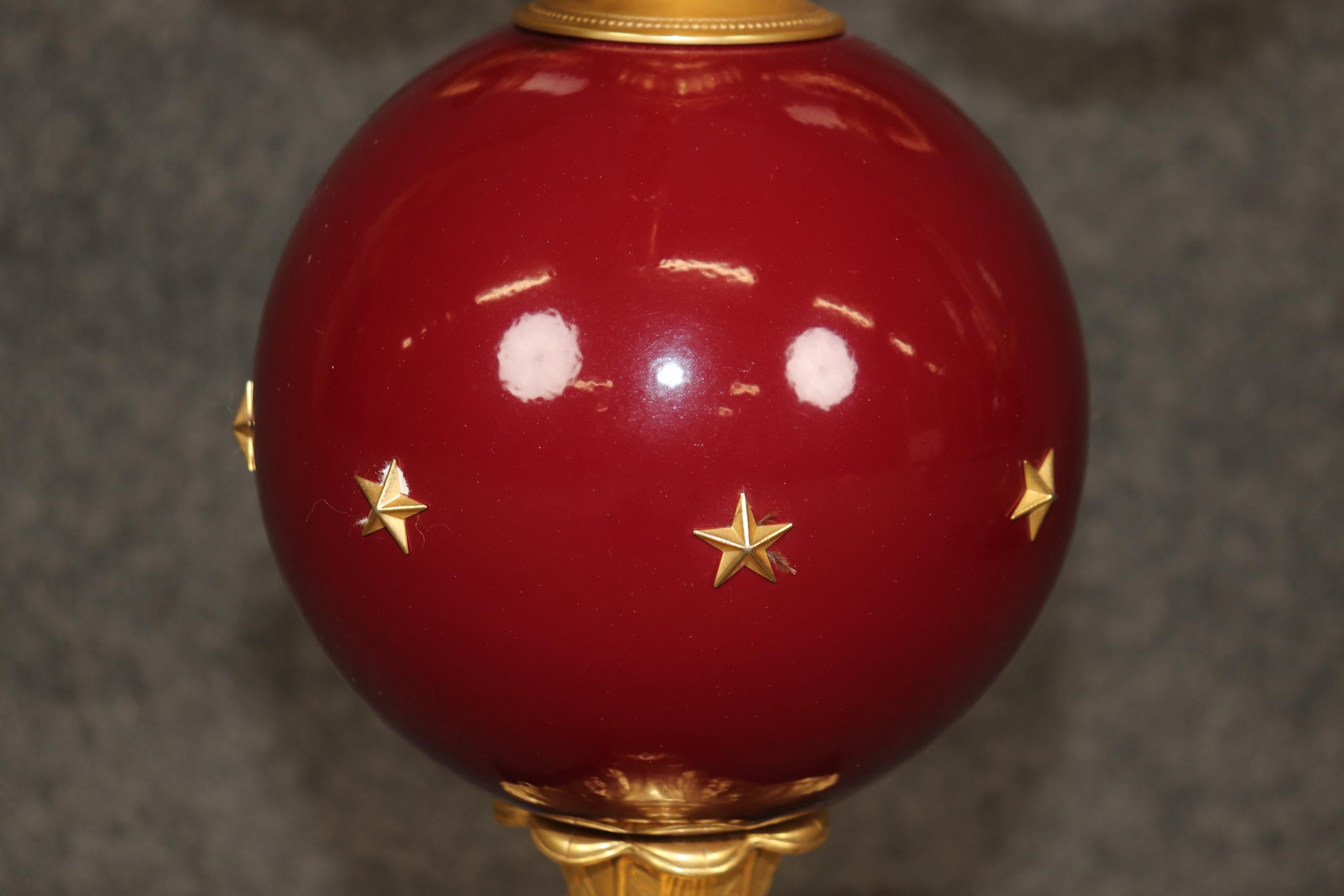 Si tratta di una coppia assolutamente mozzafiato di lampade da tavolo montate in ceramica rosso scarlatto e bronzo ormolu, in stile Impero francese con i classici piedi a zampa e le stelle sulle sfere. Sono in buone condizioni originali con minimi