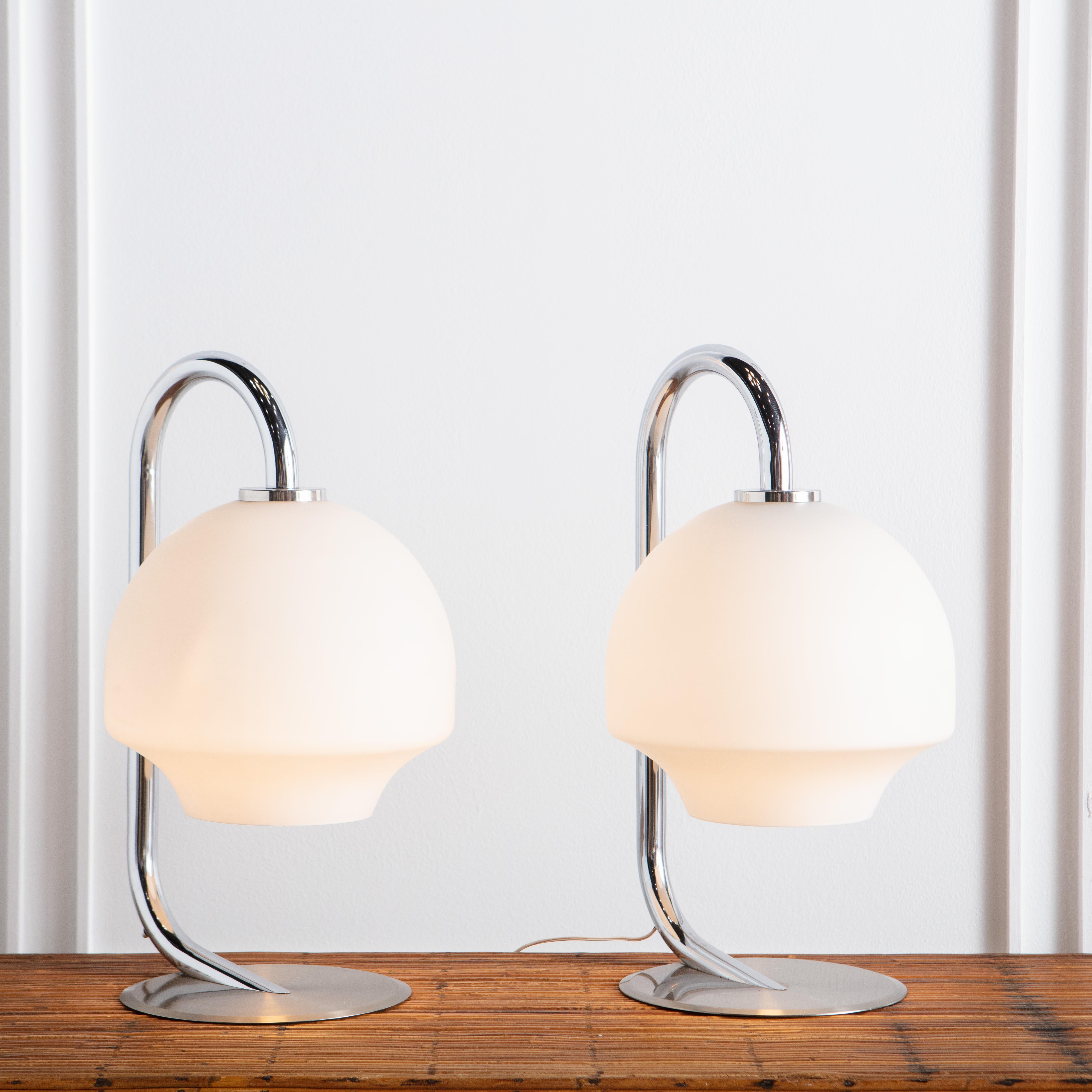 A pair of mid-20th entury table lamps from Spanish lighting manufacturer Fase. Featuring a brushed steel base and frosted glass shades that effuse a warm, ambient light. 

Fase was established in Madrid in 1964 by industrial designer Pedro Martín.