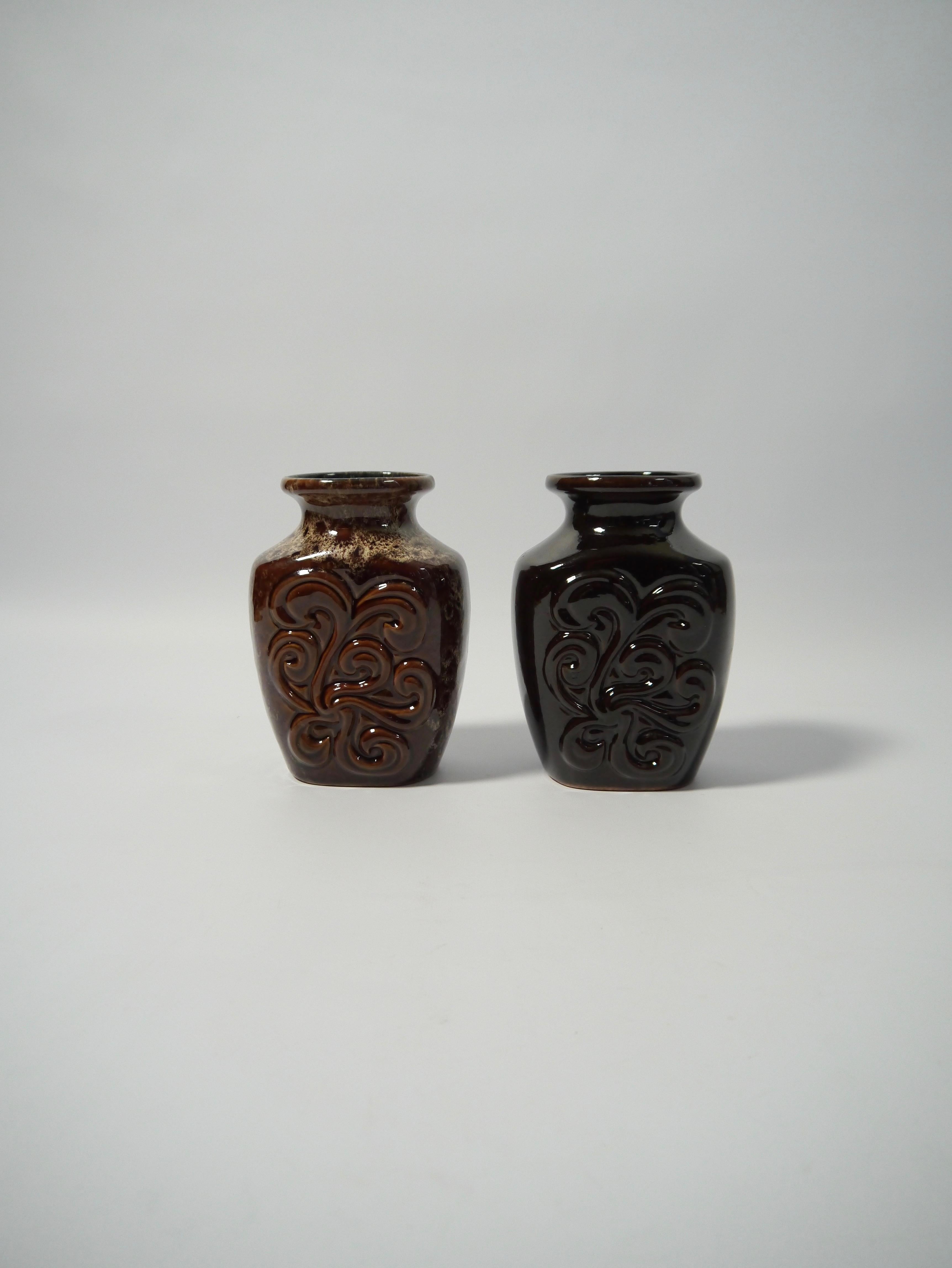 Pair of German pottery vases fabricated by Strehla former East Germany in the 1960s. One vase deep black glaze, the other in a speckled brown glaze, but both identical in dimension, shape and organic floral pattern.