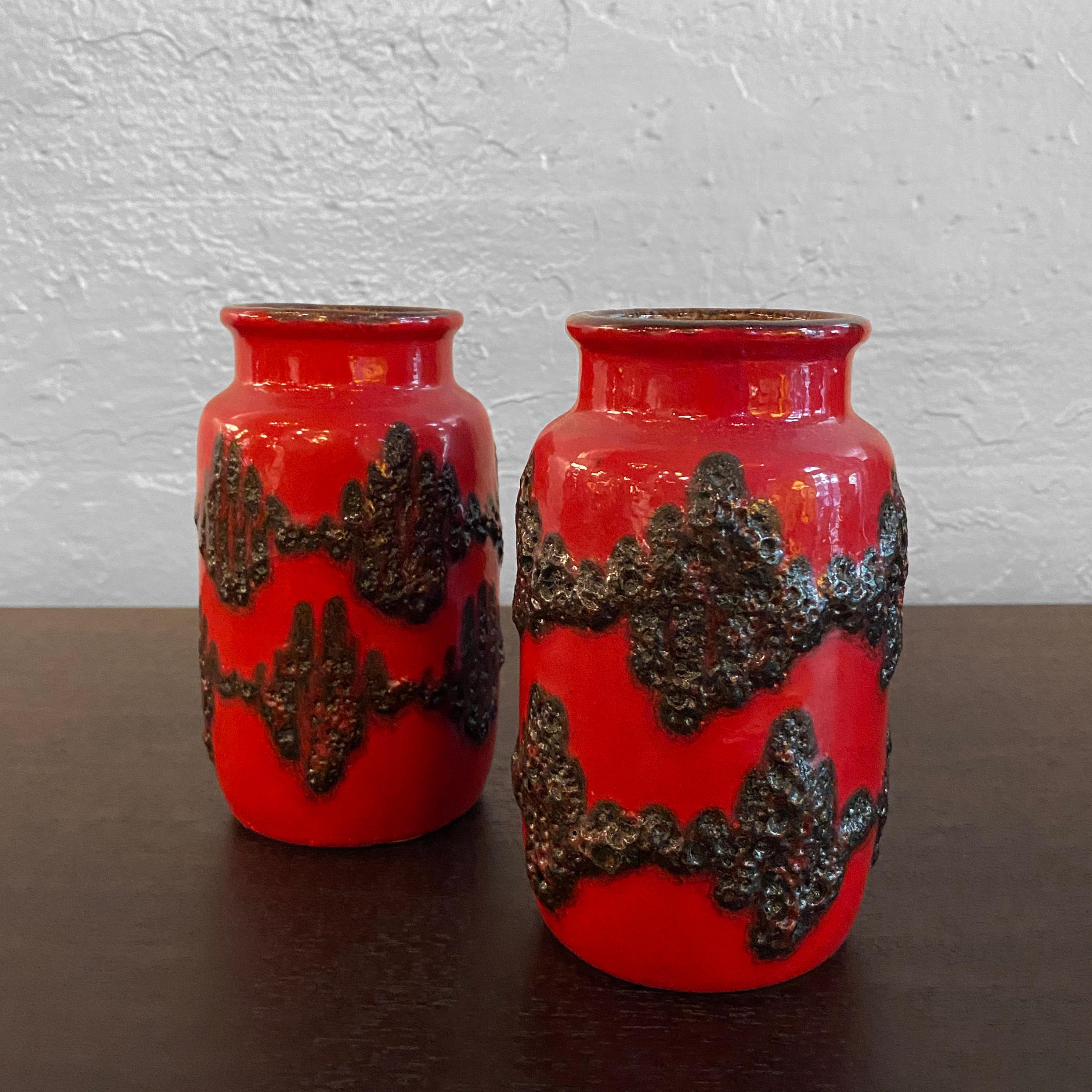 Pair of small, West German, fat lava vases by Scheurich Keramik feature striking, red and black brutalist glazes with black interiors. Their openings measure 2.5 inches diameter.