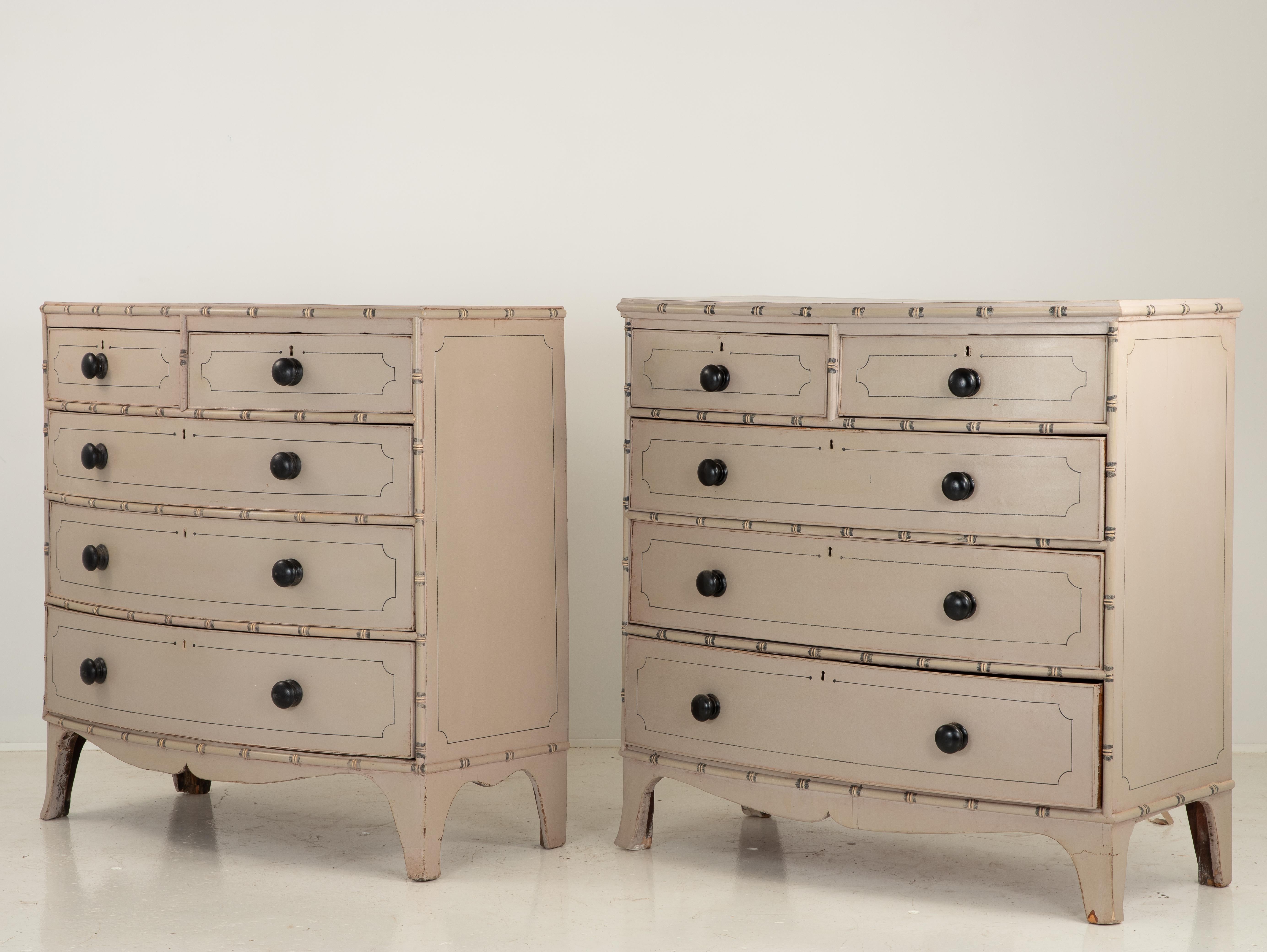 A pair of painted bowfront French chests of drawers in an updated chinoiserie style with splay legs. Two drawers of three drawers for a generous scale. Bamboo detail and recent paint with a pinstripe paint have been added. These are a matched pair