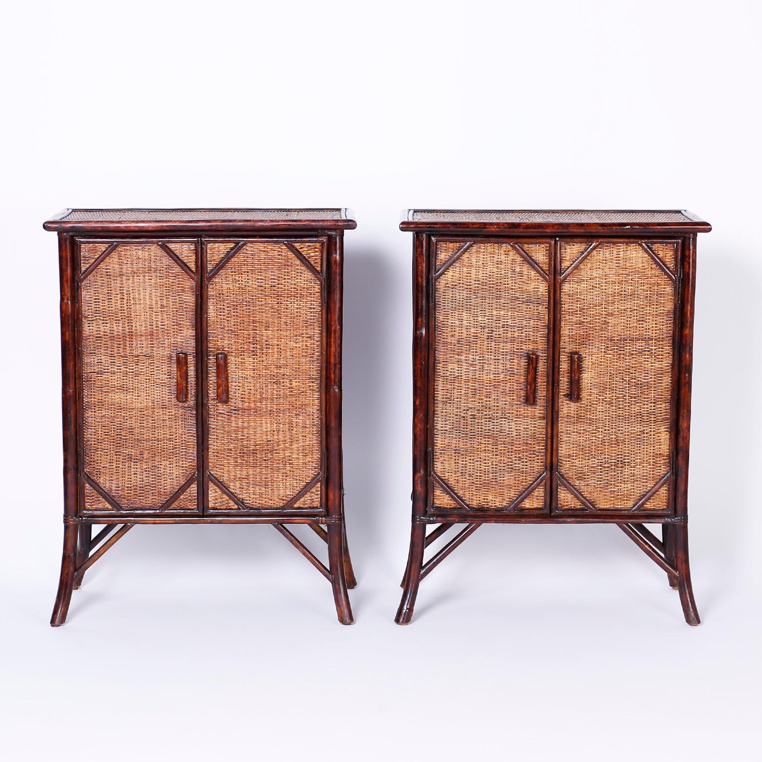 Handsome pair of two door cabinets having faux bamboo frames with Asian style splayed legs, rugged grasscloth or woven wicker tops, sides and fronts with plenty of open storage and hard to find slim profiles.