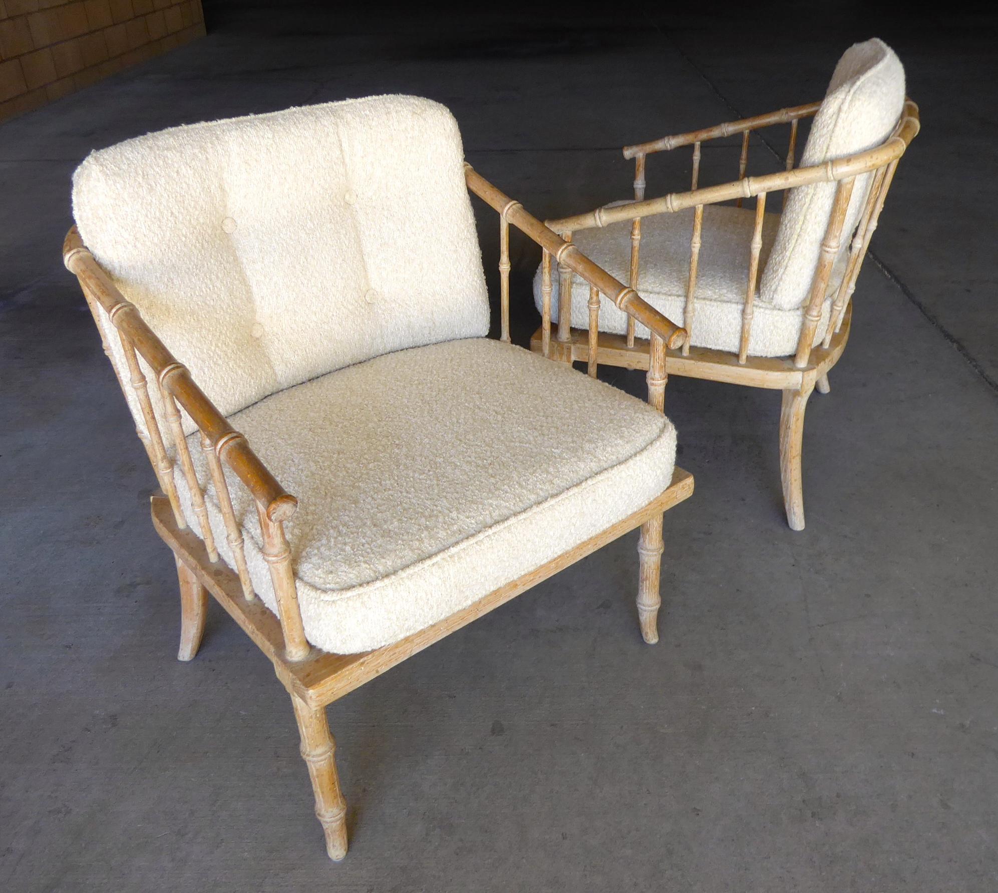A pair of faux-bamboo carved oak armchairs with a lime-washed finish, attributed to McGuire, circa 1960s. The cushions have been newly reupholstered in a cream colored nubby boucle fabric.