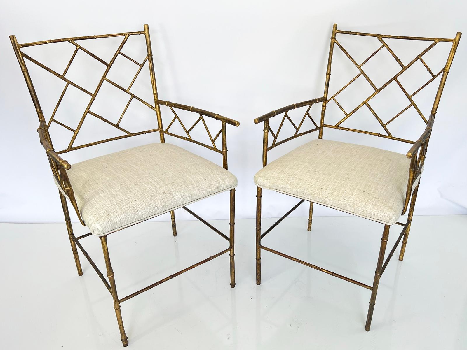 Pair of armchairs, of gilded iron, each frame fashioned as bamboo, having squared backrest and armrests inset with fretwork in Chinese Chippendale taste, the crown seat of linen on four legs, joined by a box-stretcher. 

This classic design works