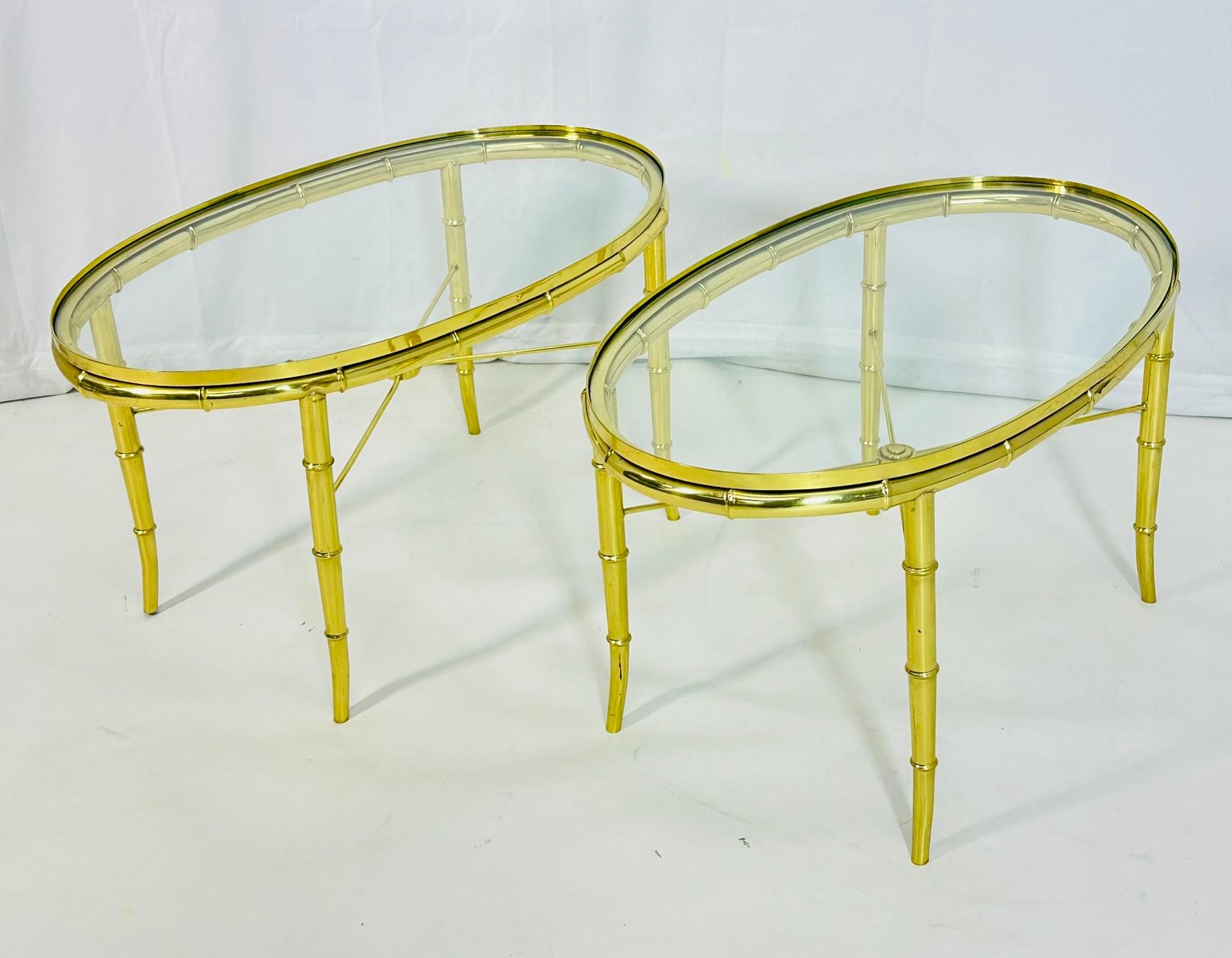 Stunning pair of oval side tables designed and manufactured in the United States in the 1970's.

The tables have beautiful brass frames with faux bamboo design, each table has a glass top brass stretchers connecting the four legs.

The chairs are