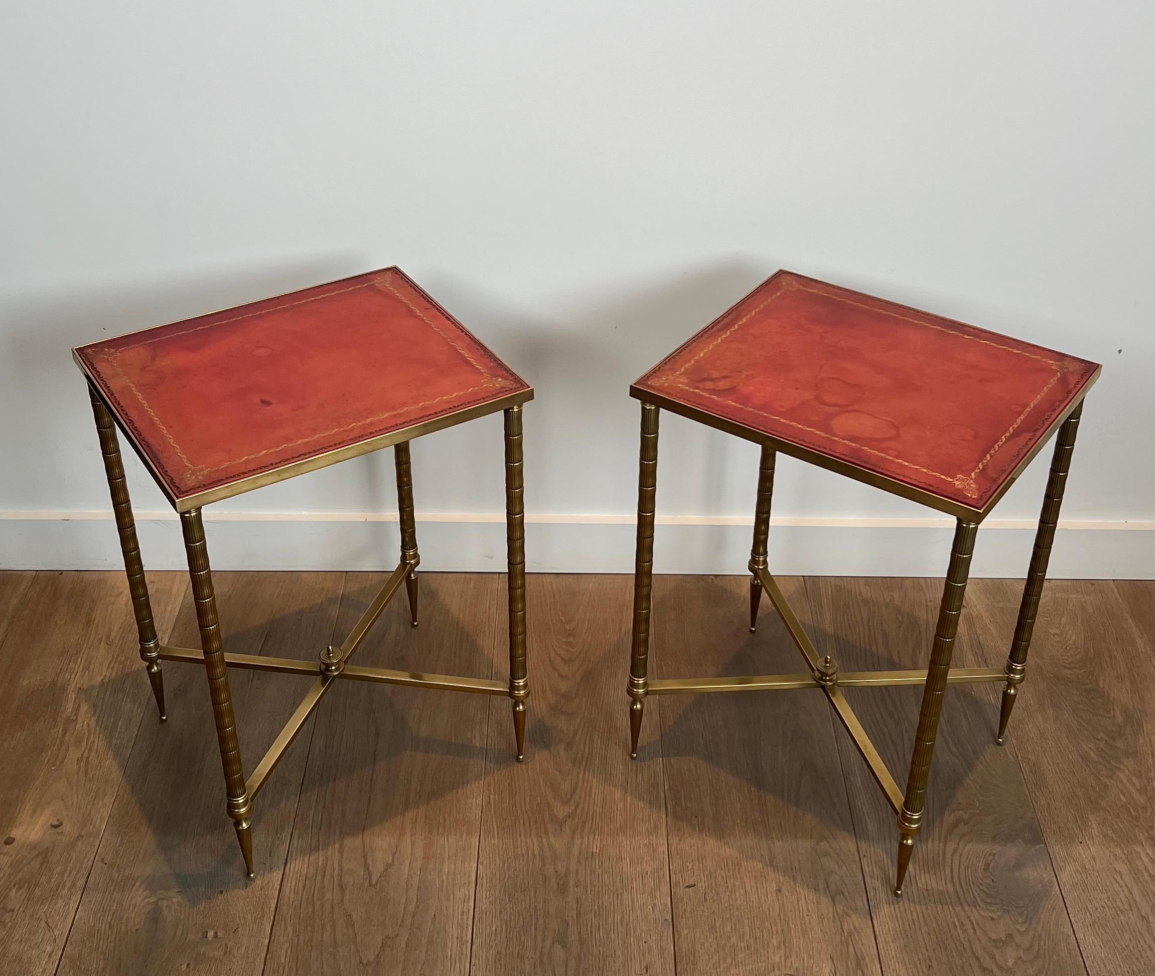 This pair of neoclassical style faux-bamboo side tables is made of brass with red leather Tops. This is a French work by Maison Jansen. Circa 1940