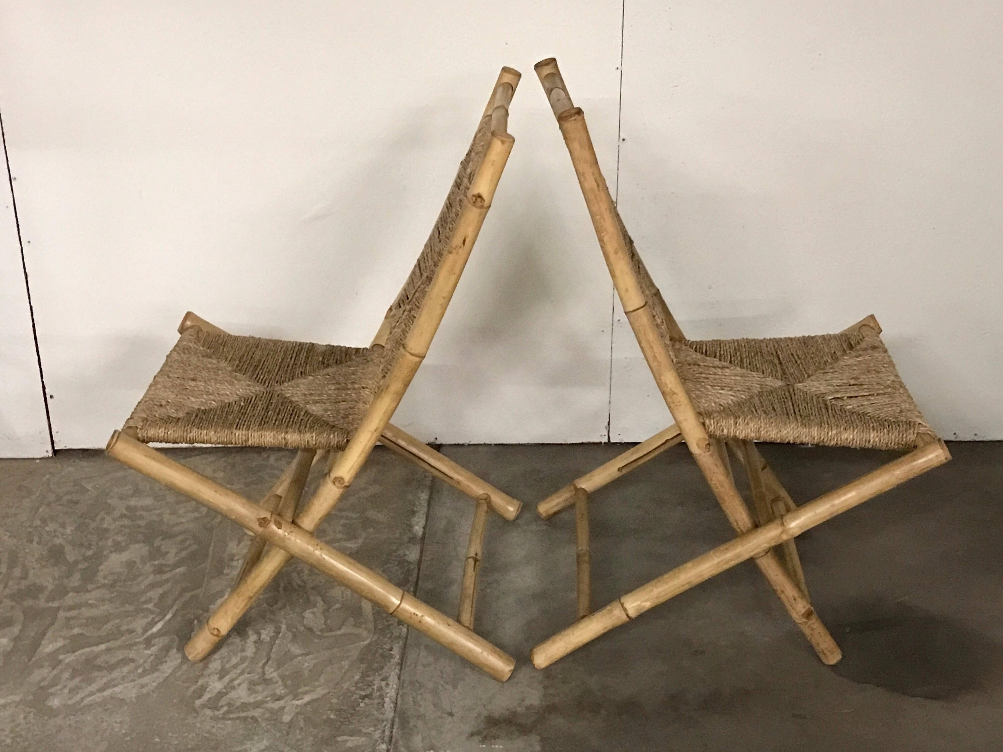 Pair of Faux bamboo campaign chairs, in the manner of Maison Jansen, Each one with rush back rests and seats, they fold for storage.