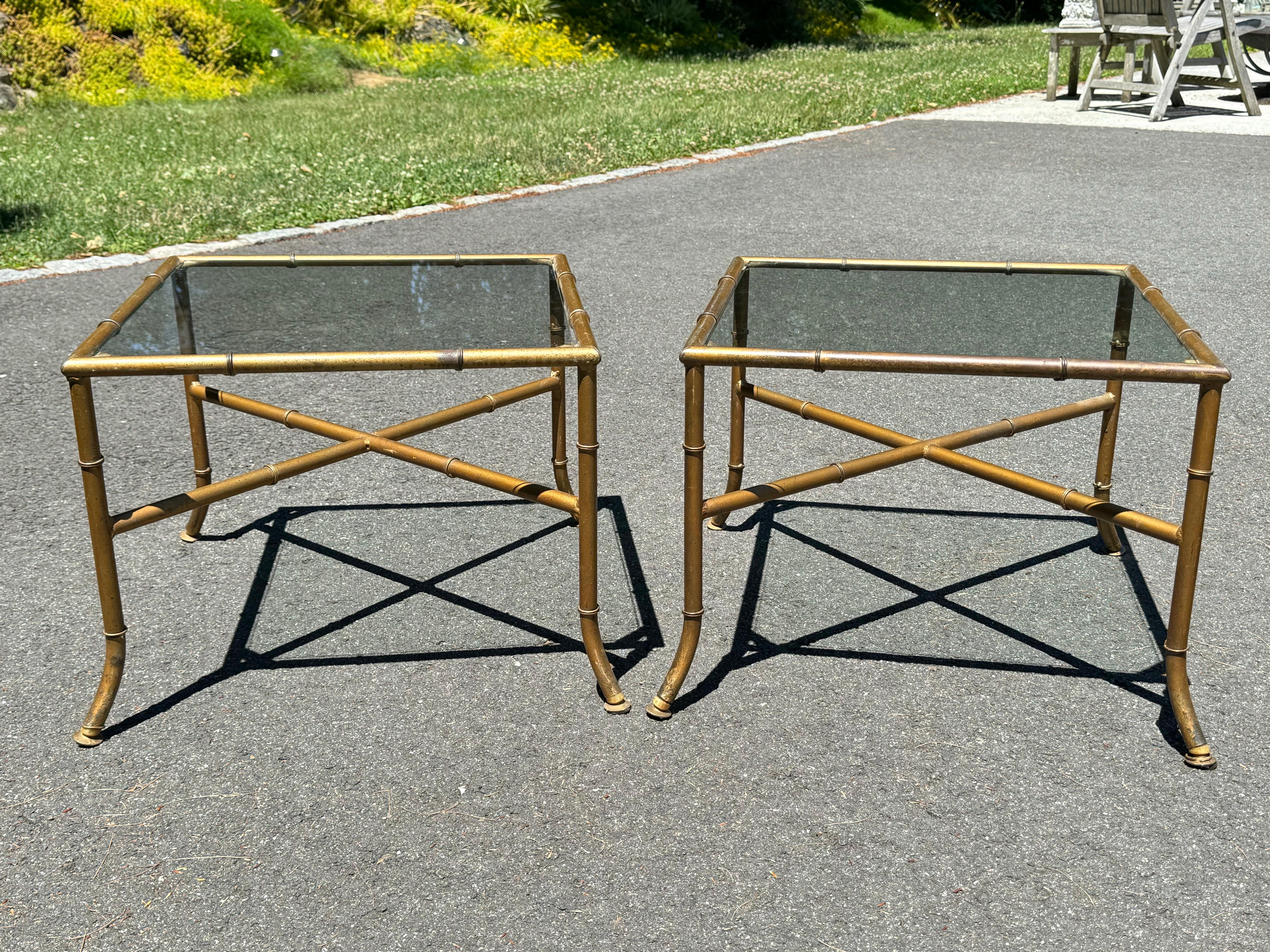 Paire de tables d'appoint en faux bambou ou tables basses. Tables peintes en or avec des plateaux en verre transparent et une base en forme de barre transversale. Belle taille et construction solide. A utiliser comme tables d'appoint ou la paire