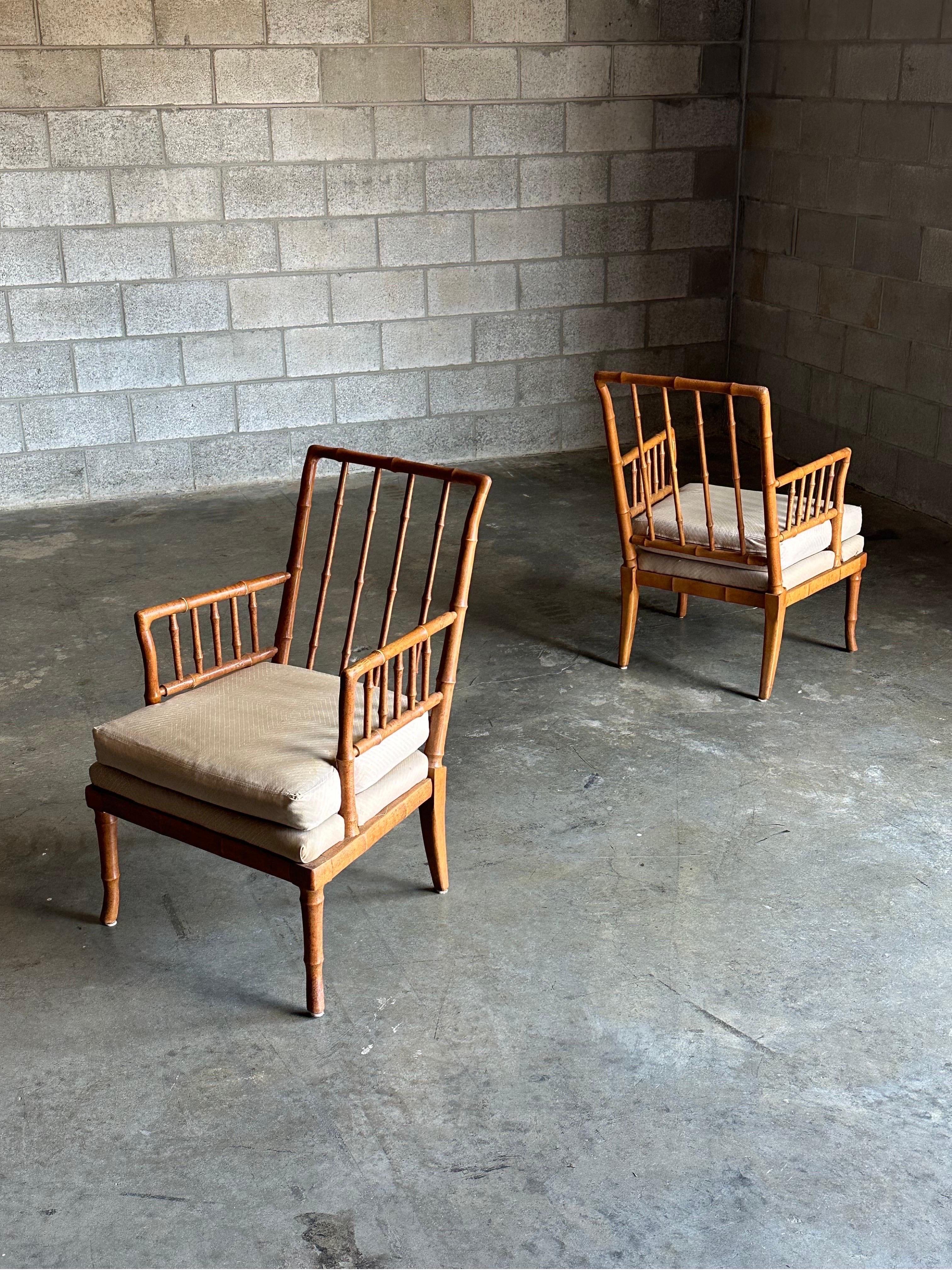 Gorgeous pair of vintage faux bamboo chairs with T.H. Robsjohn-Gibbings styled flared legs. Very unique chairs featuring faux bamboo throughout, a spindle style back and arms. Unique size allows for lots of applications- pair of club chairs, accent